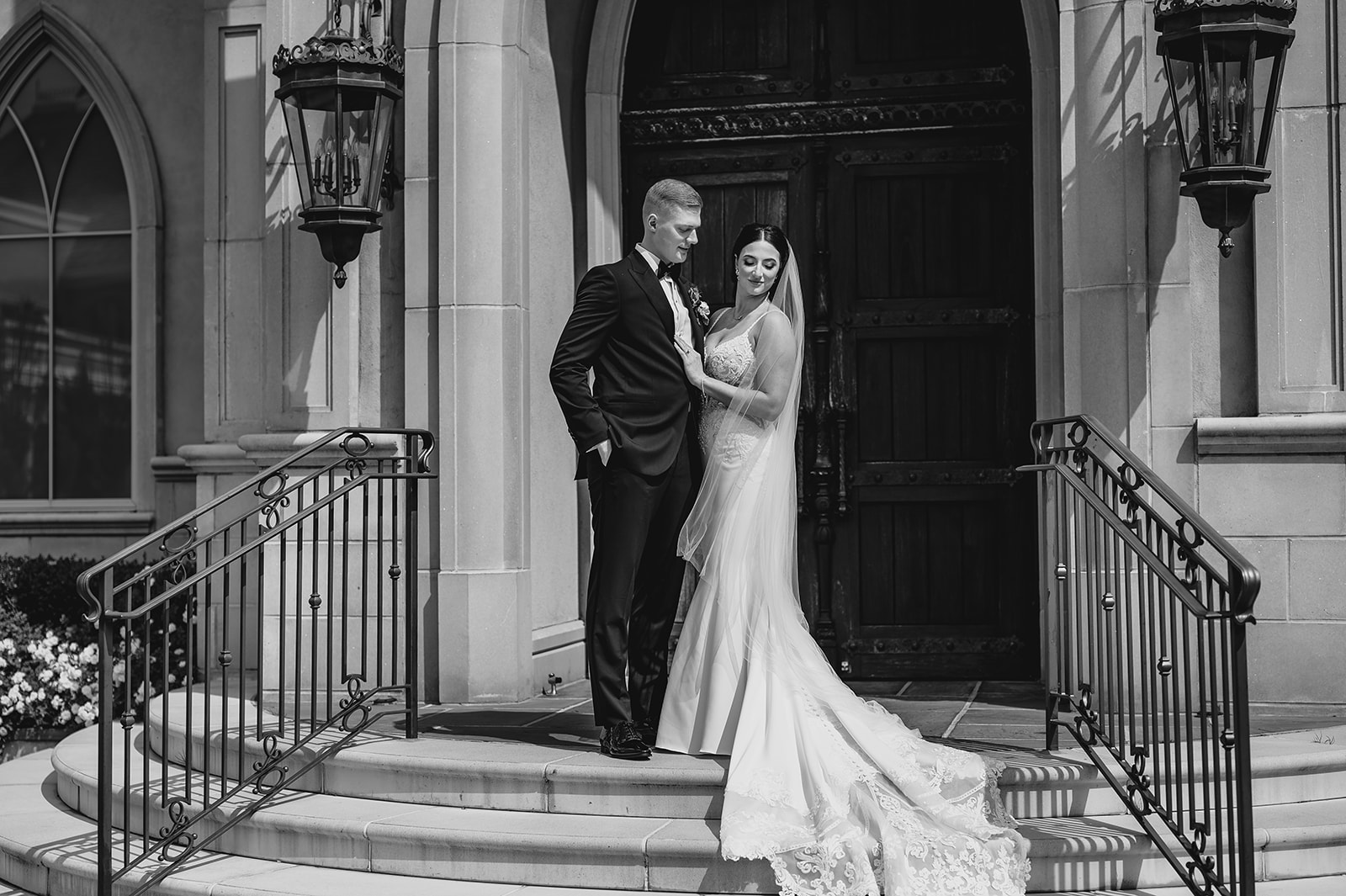 bride holds groom's chest on stop of steps at Park Chateau chapel