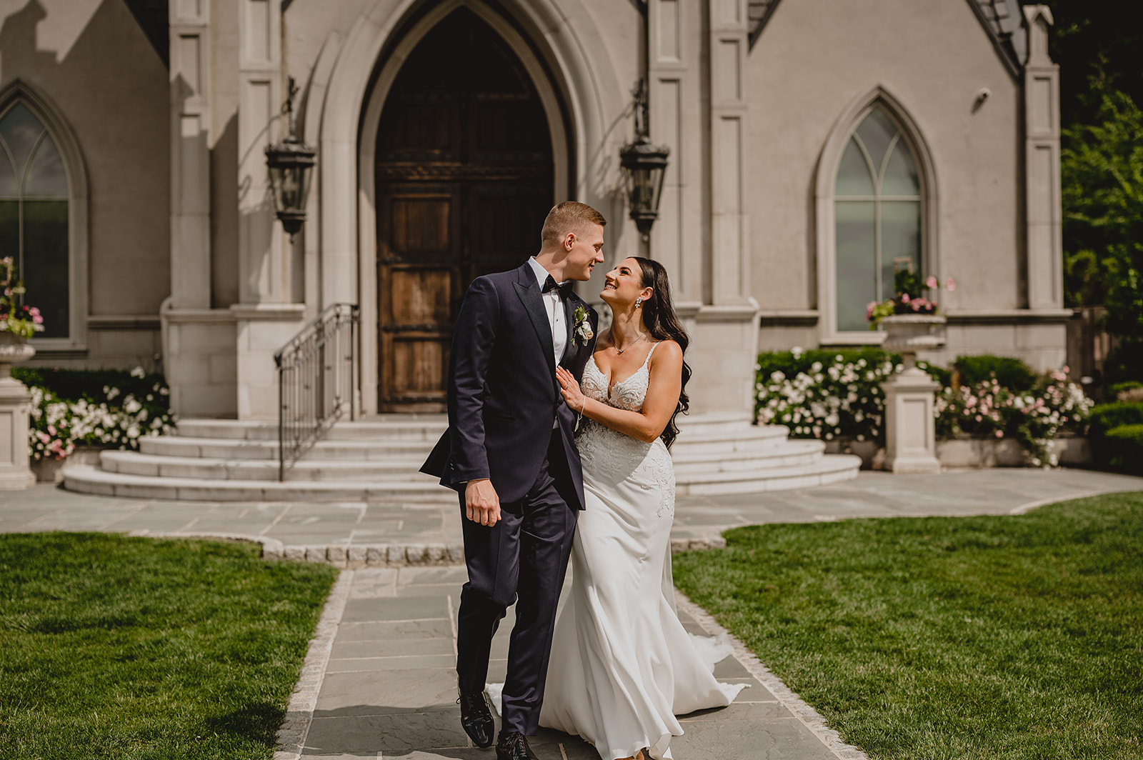 bride and groom smile walking away from the Park Chateau chapel