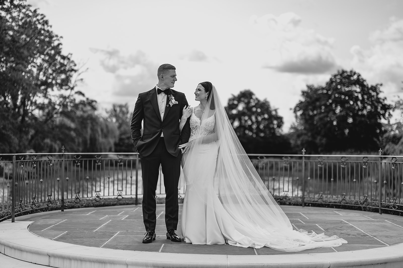 bride holds groom's arm on stone patio at Park Chateau Estate