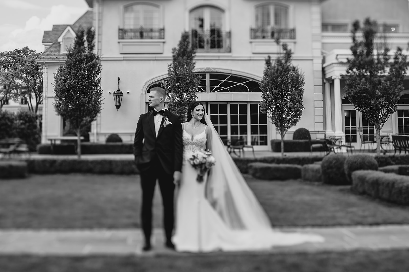 bride holds groom's arm looking to the side at Park Chateau Estate