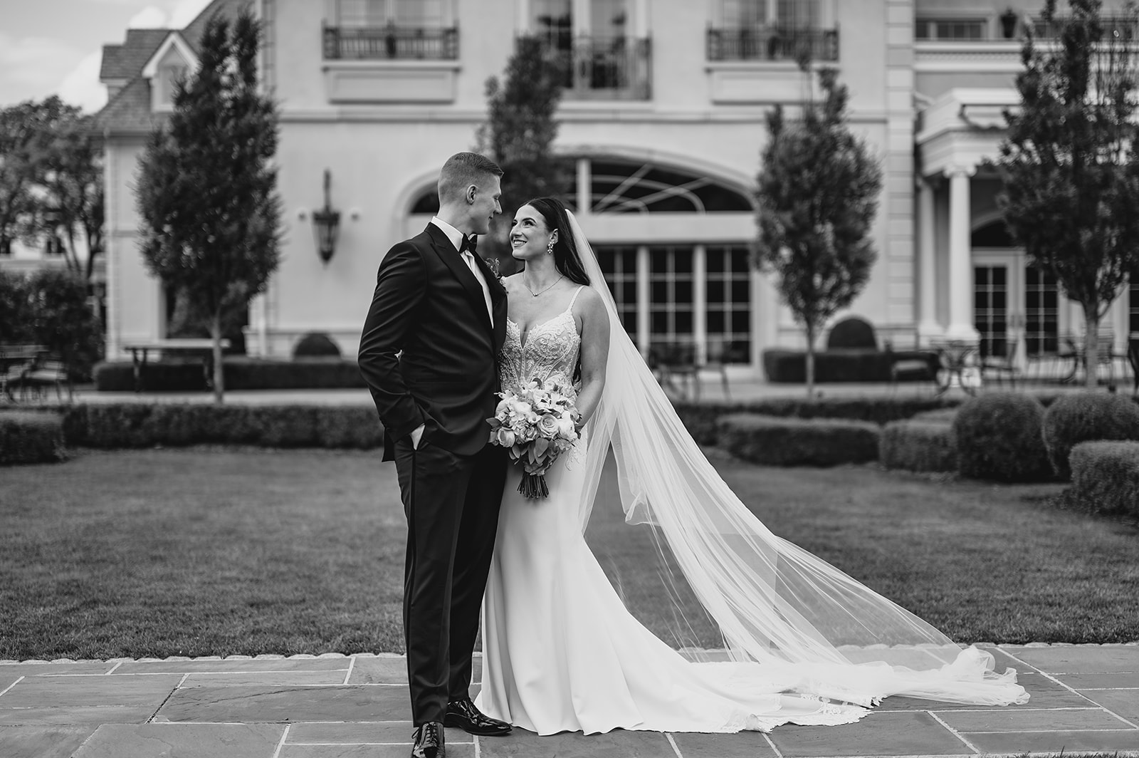 newlyweds hug in front of Park Chateau Estate