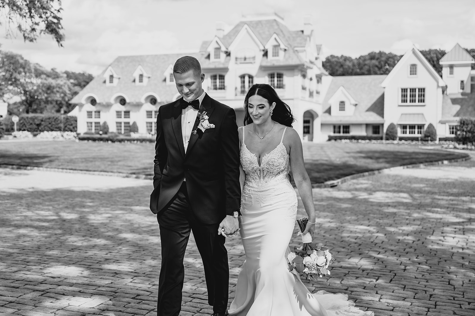 newlyweds hold hands walking outside Park Chateau Estate