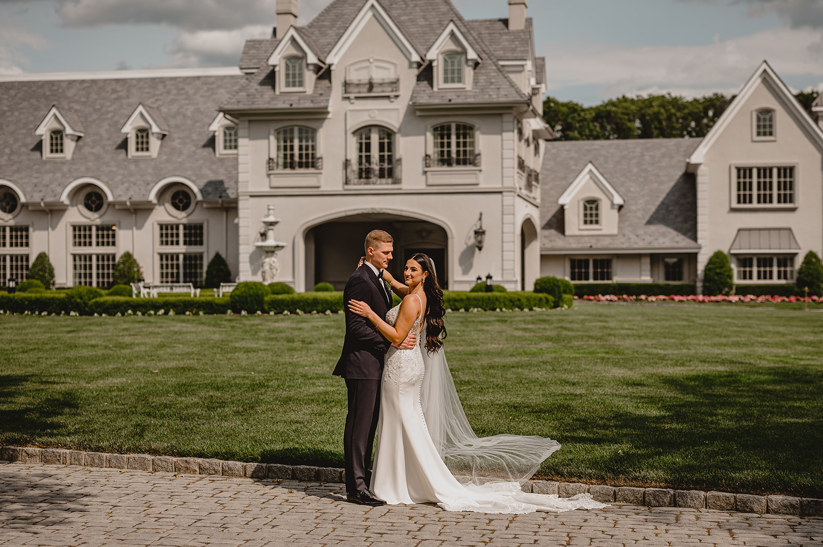 bride and groom hug in front of Park Chateau Estate