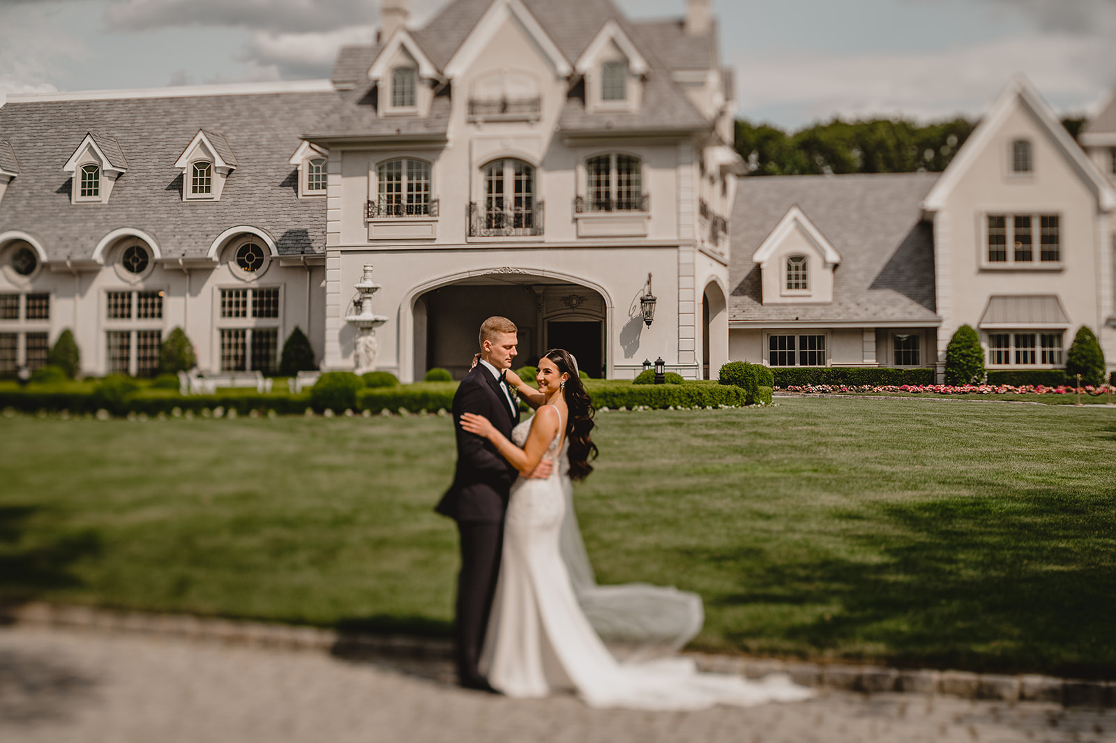 newlyweds hug in front of Park Chateau Estate
