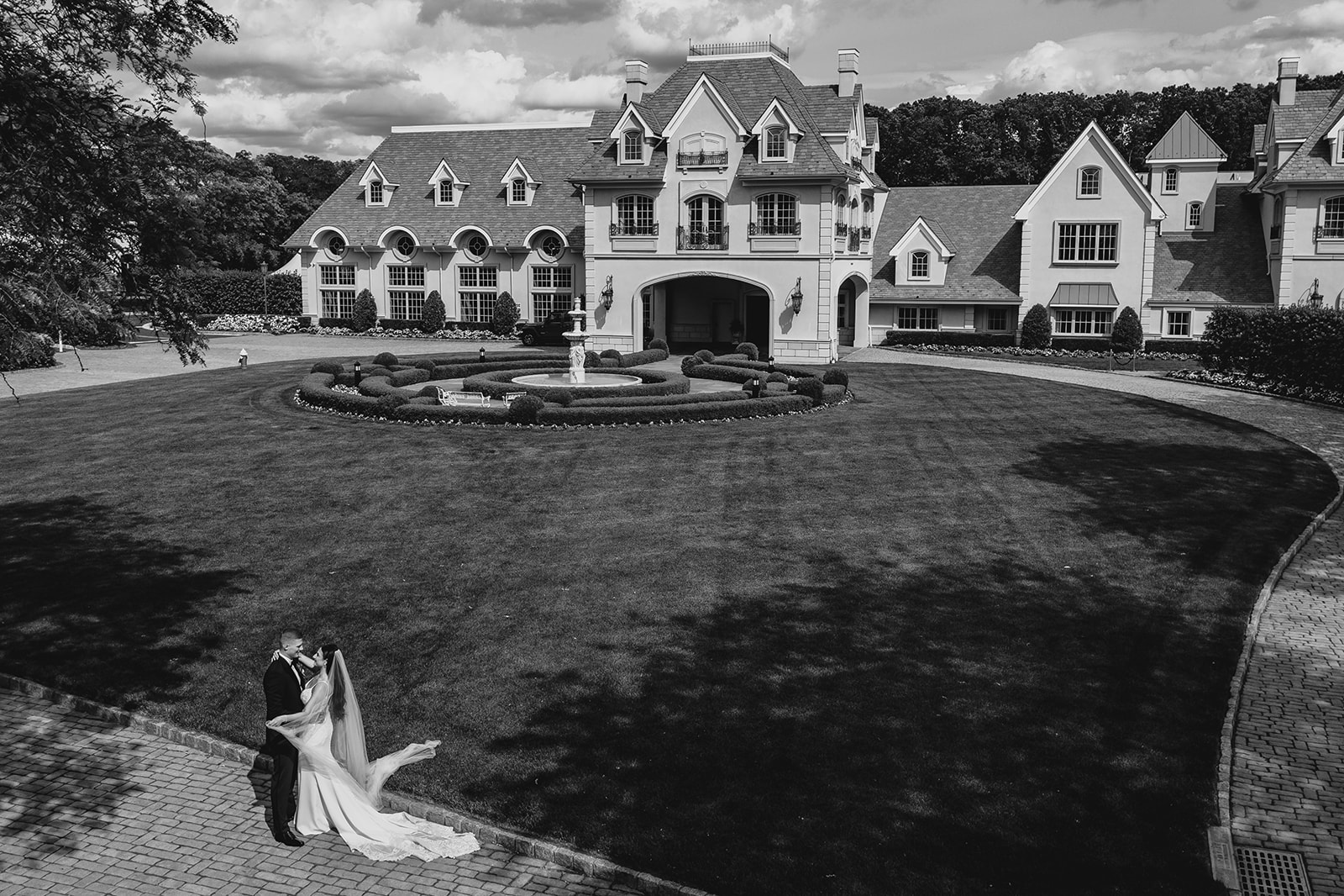 drone shot of bride and groom hugging in front of Park Chateau Estate