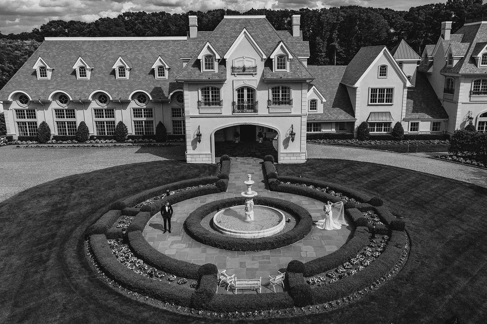 drone shot of bride and groom hugging in front of Park Chateau Estate