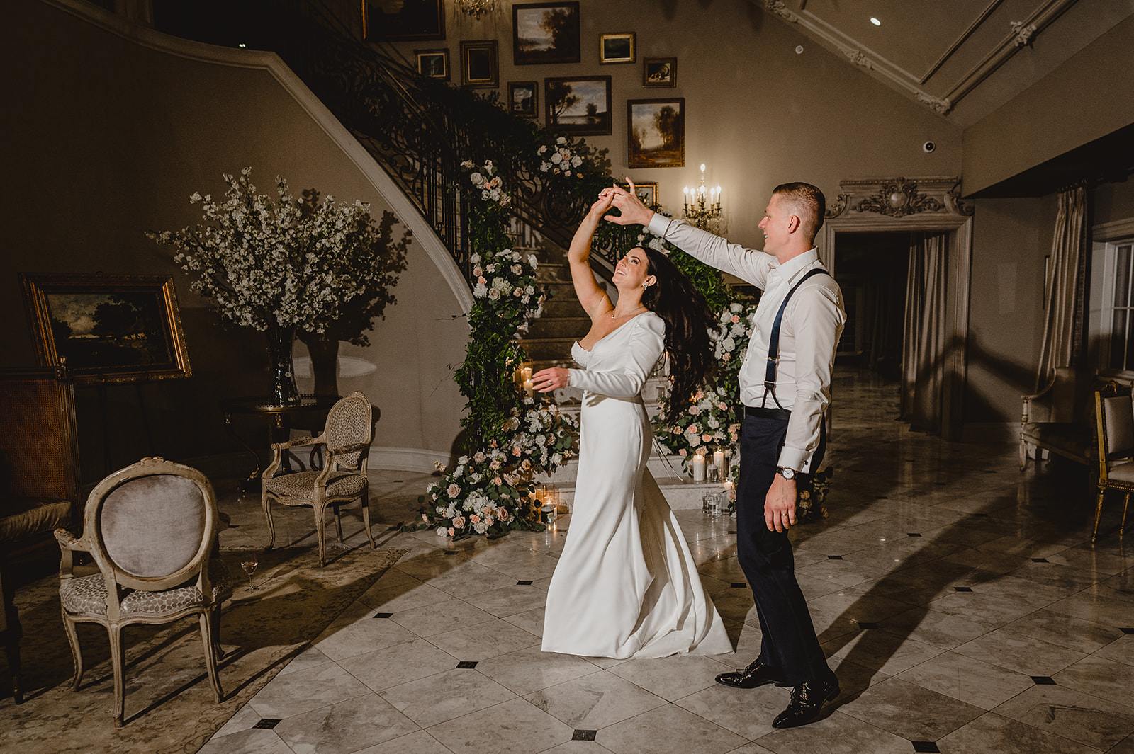 newlyweds dance together outside staircase inside Park Chateau Estate
