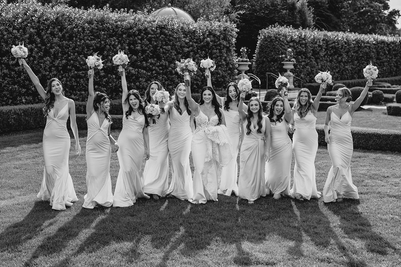 bride cheers with bridesmaids outside leaving the Park Chateau Estate chapel