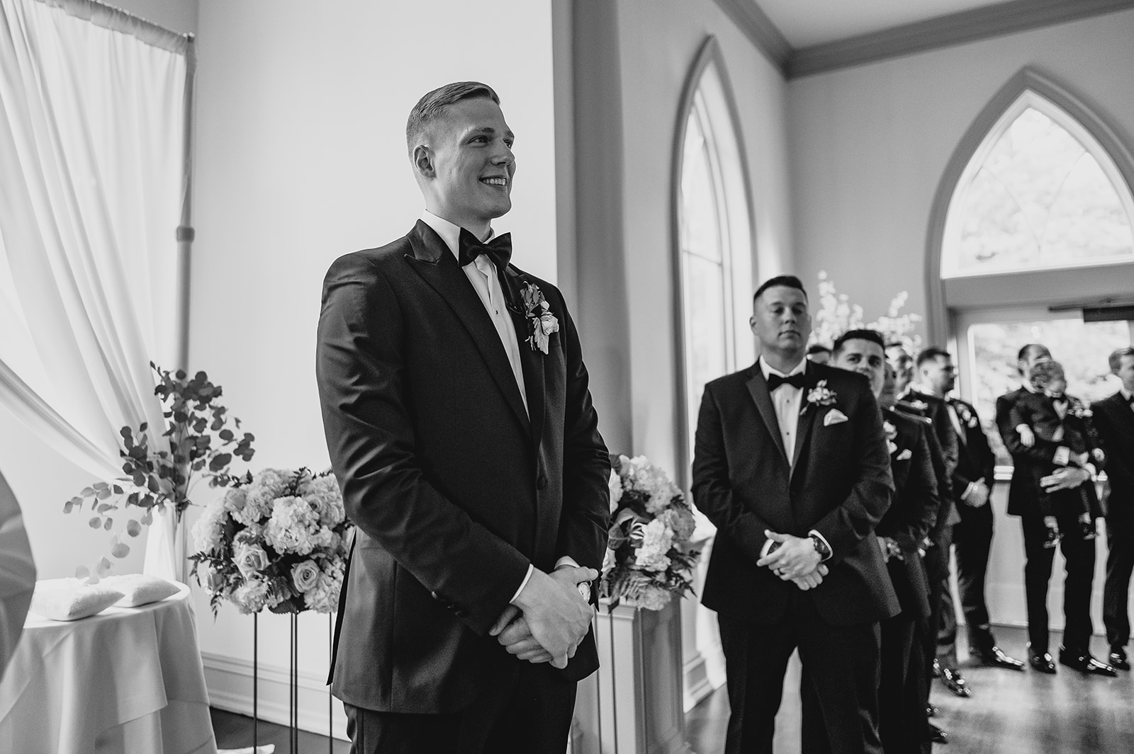 groom smiles watching bride during ceremony inside the chapel at Park Chateau Estate
