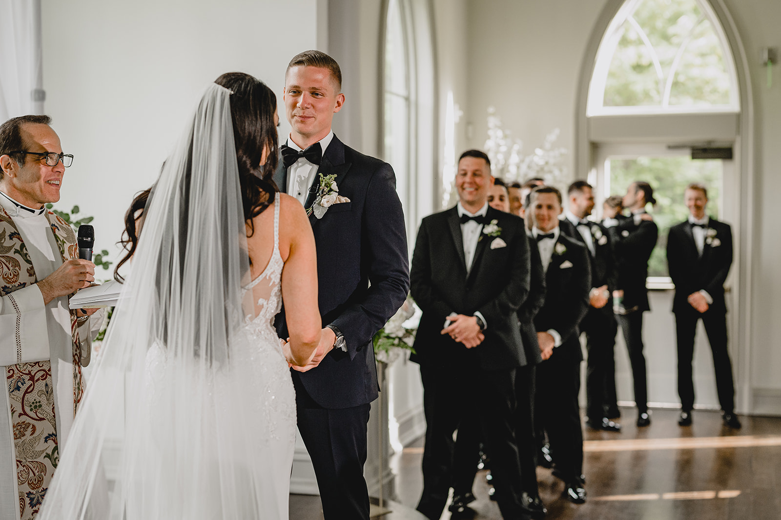 bride and groom hold hands during ceremony inside the chapel at Park Chateau Estate