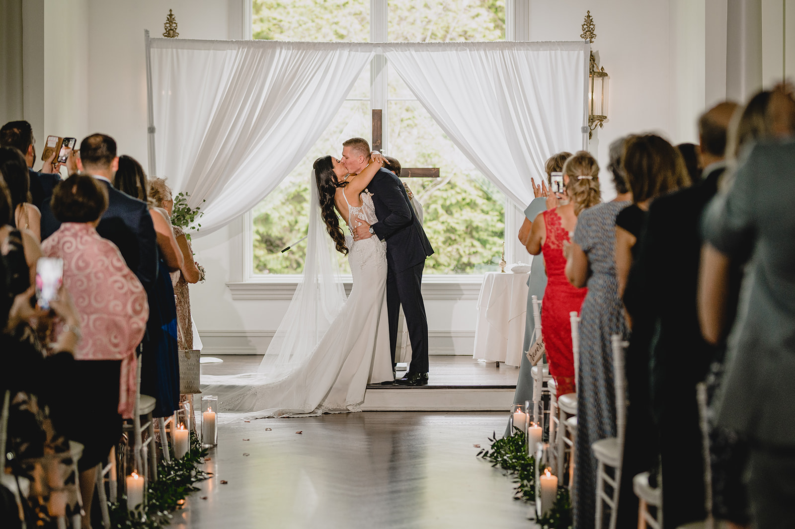 bride and groom kiss during ceremony inside the chapel at Park Chateau Estate