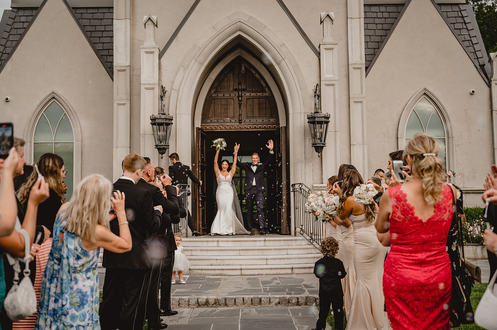bride and groom cheer leaving the Park Chateau Estate chapel