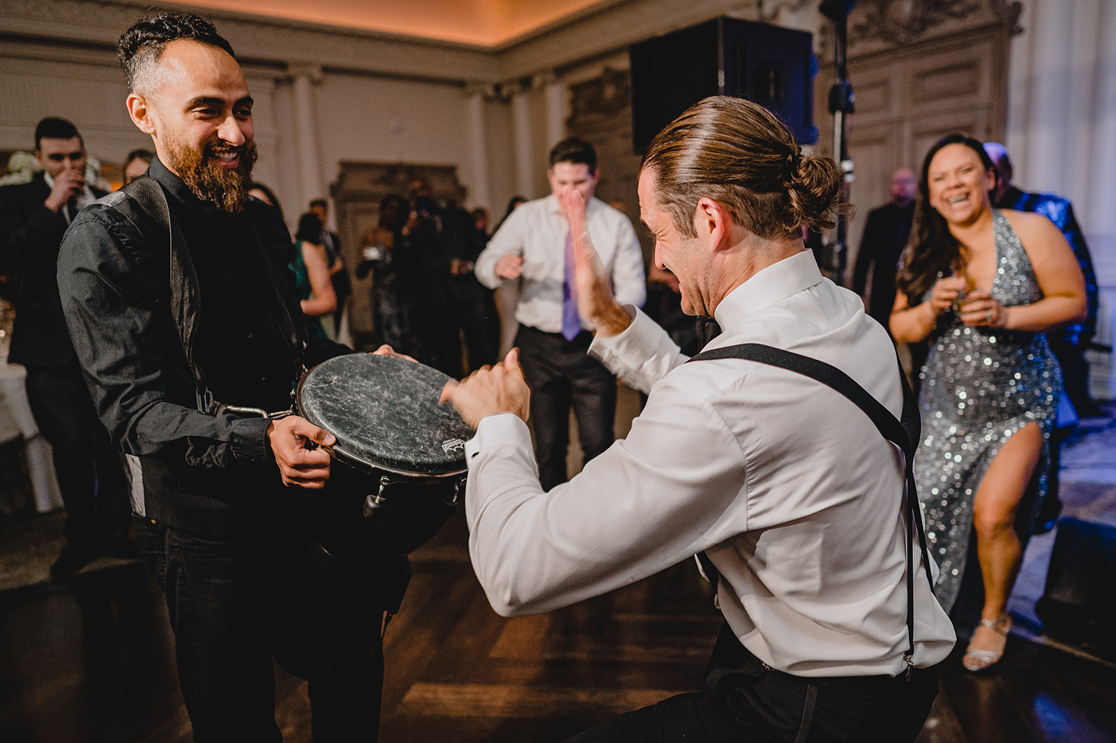 wedding guest bangs on drum during NJ wedding reception