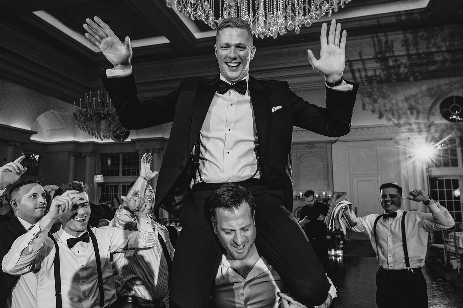 groomsman sits on man's shoulders during NJ wedding reception
