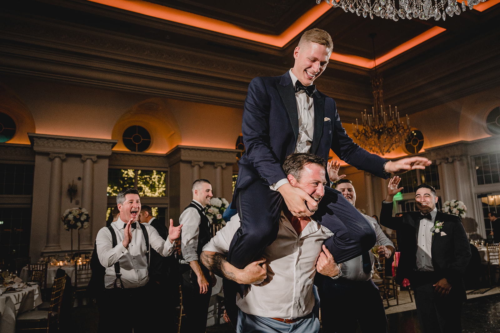 groomsman lifts up groom during NJ wedding reception