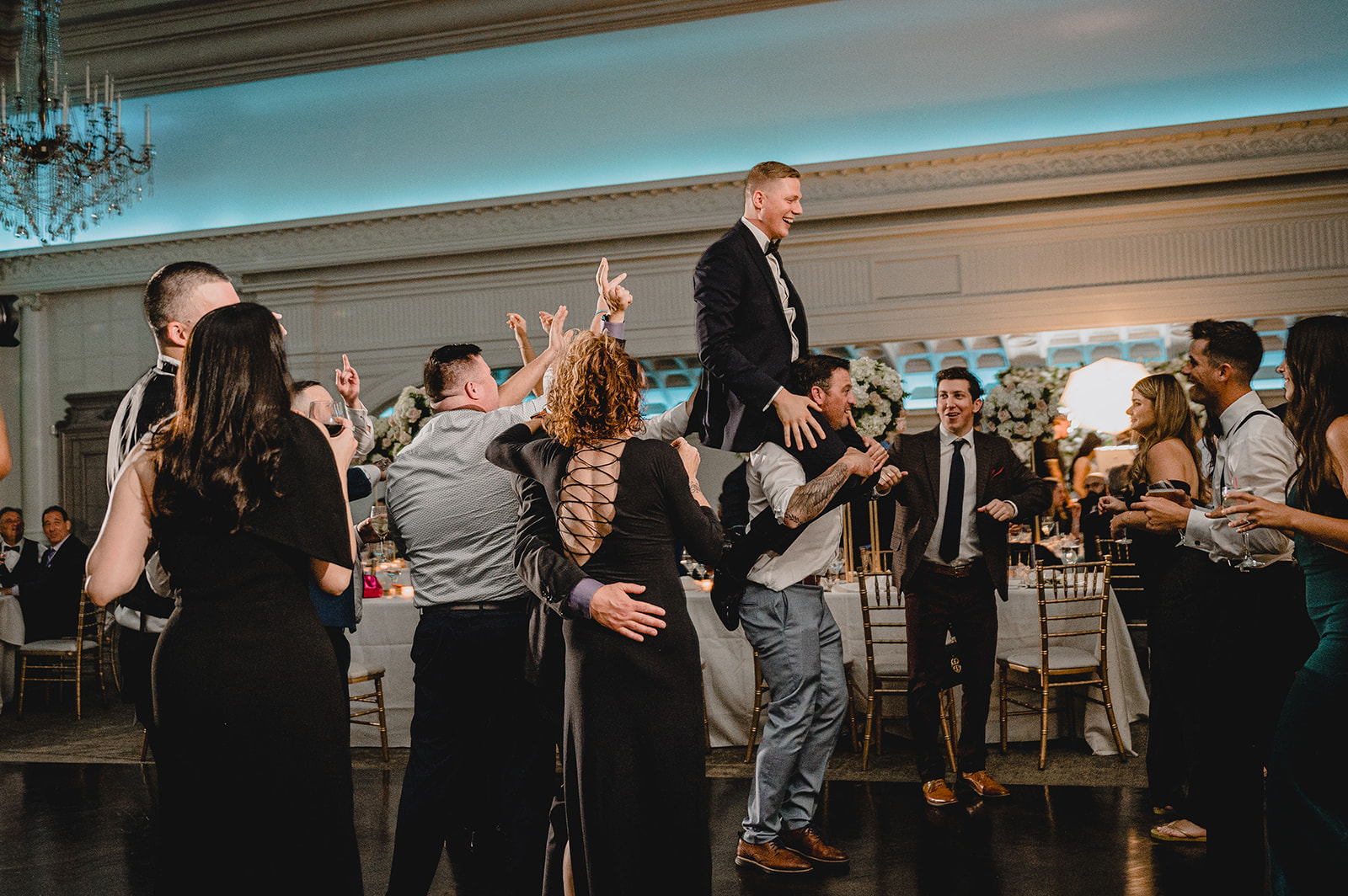 groomsmen lift up groom during NJ wedding reception