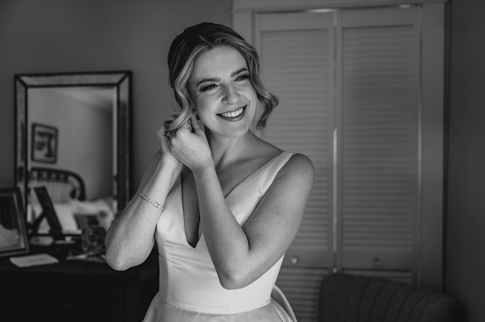 bride adjusts earrings during prep for NJ wedding