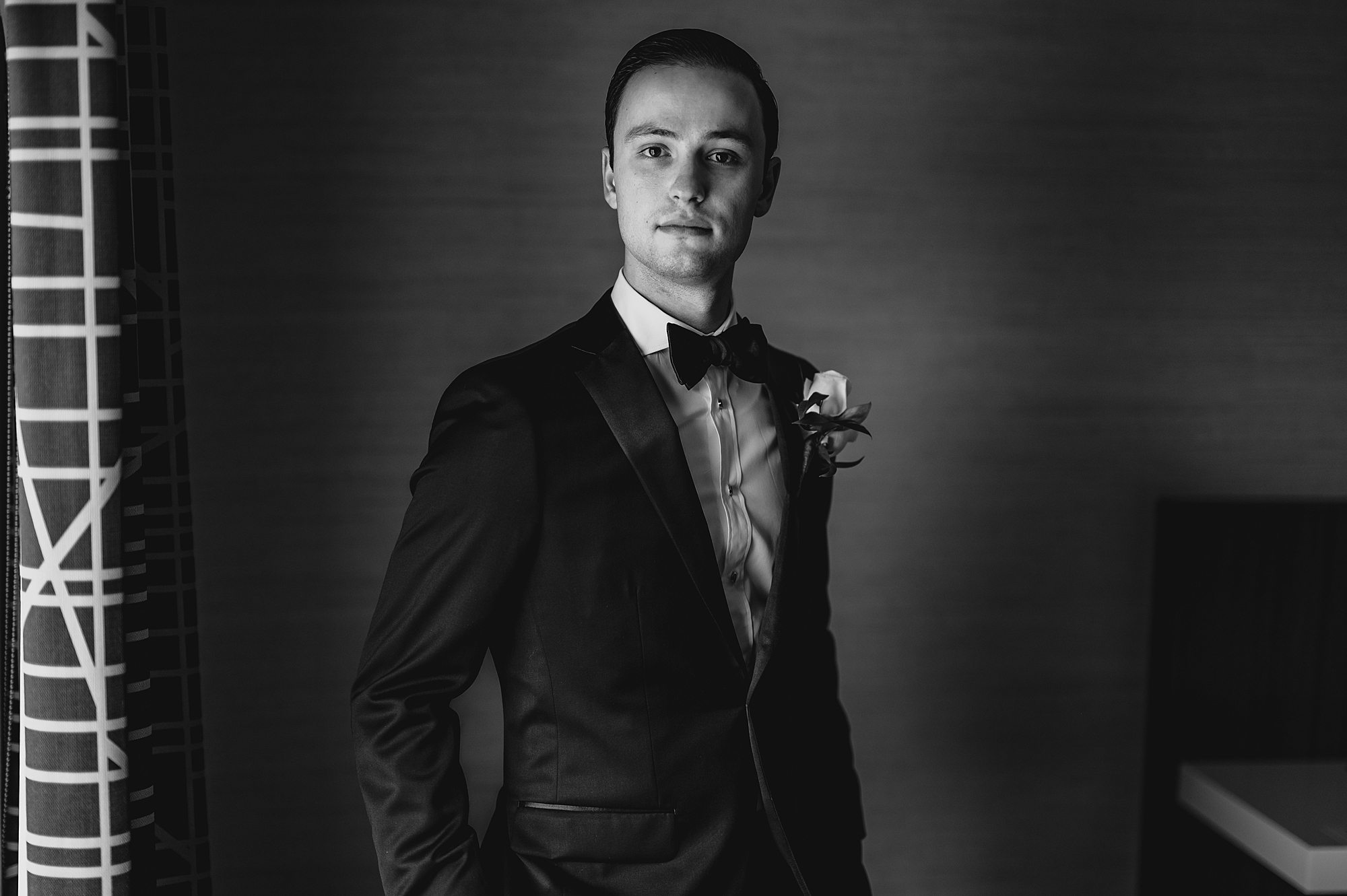 groom stands with hands in pockets of suit jacket 