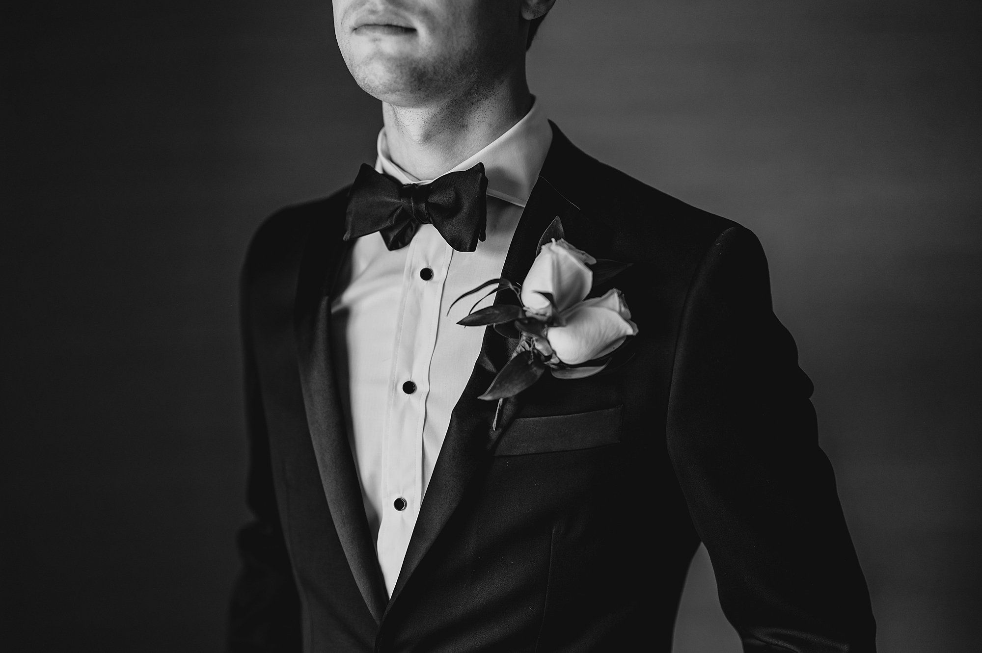 groom shows off bowtie and boutineere 