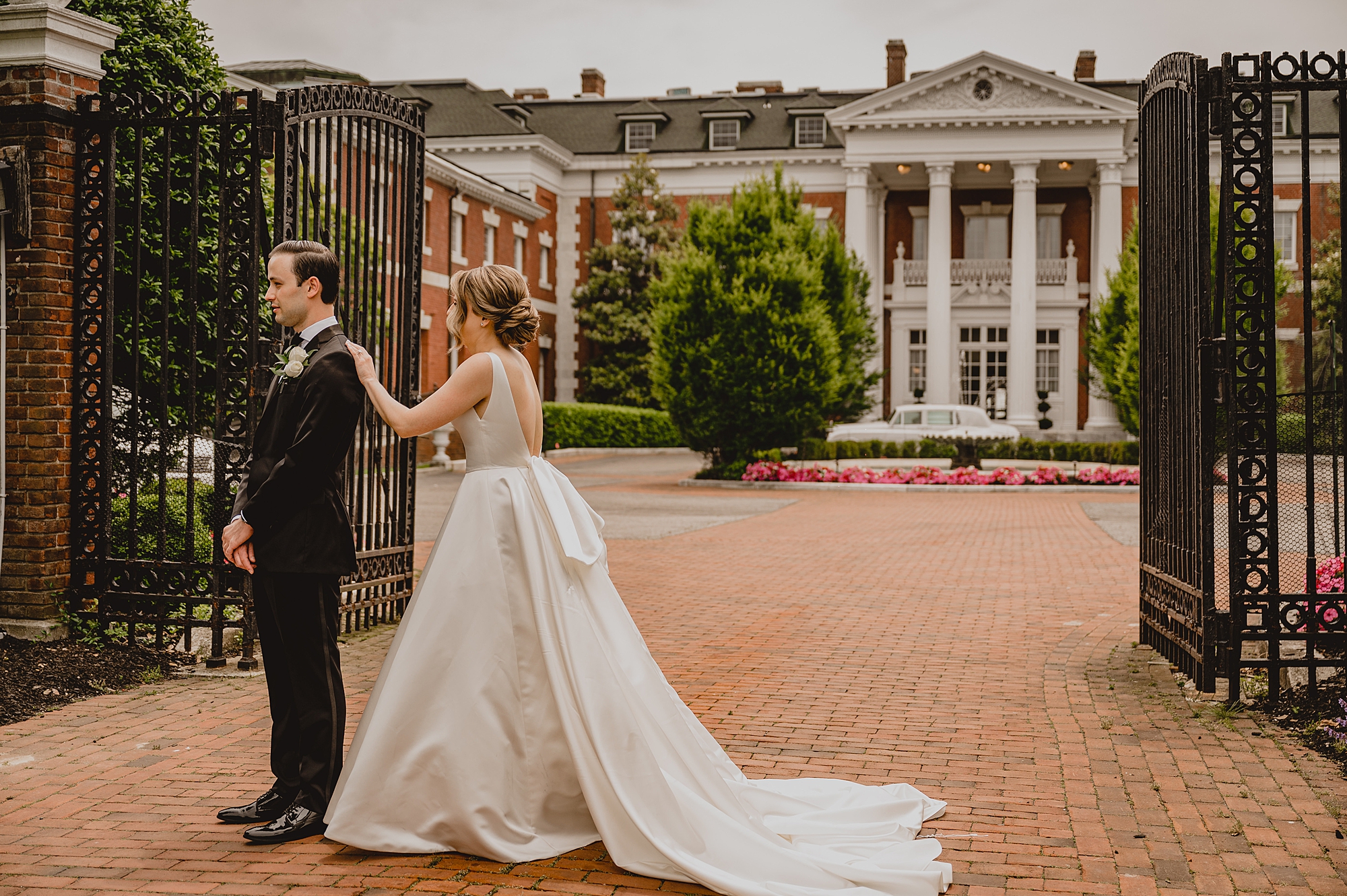 bride taps groom's cheek outside Bourne Mansion