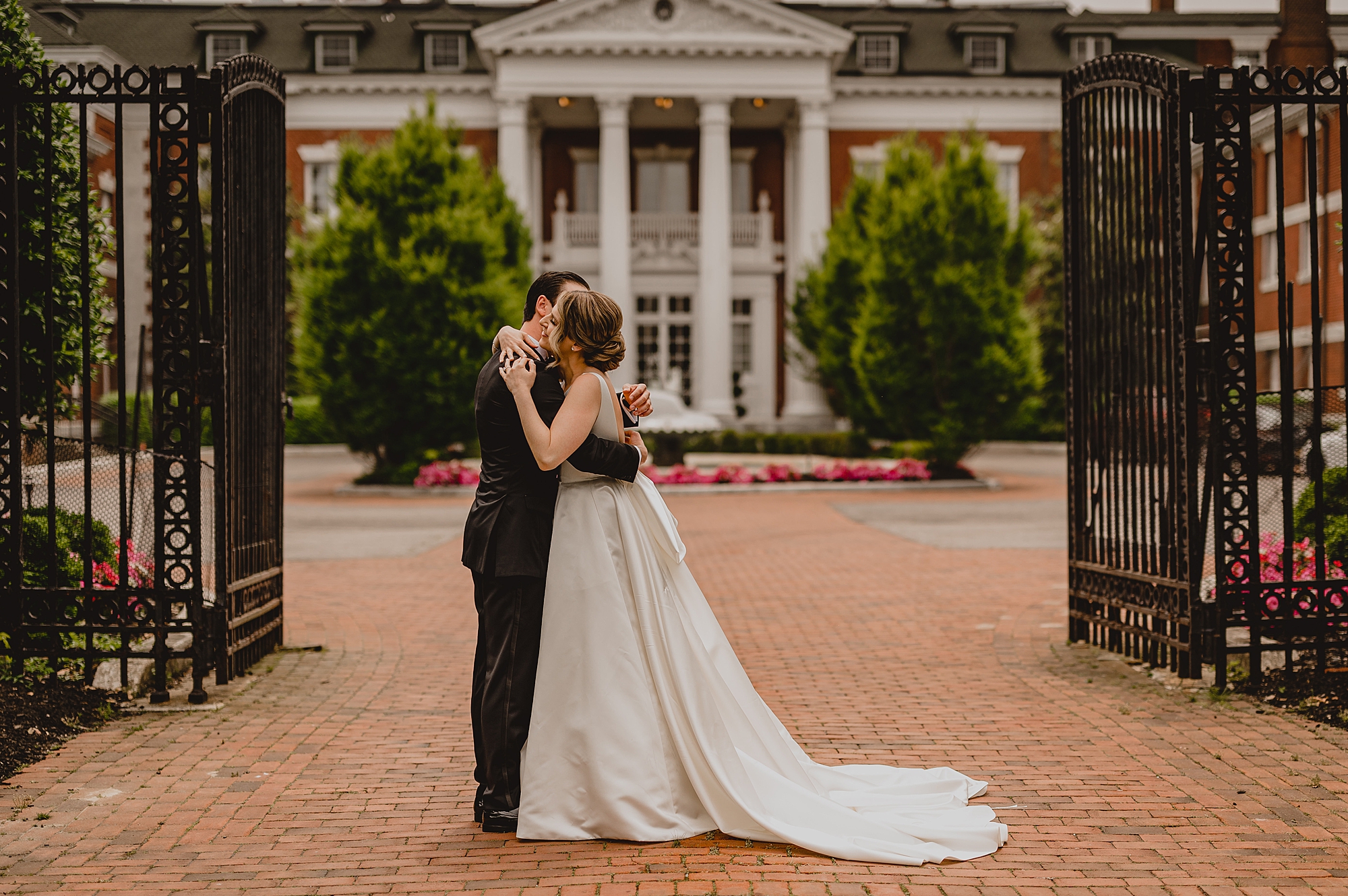 bride and groom kiss outside Bourne Mansion