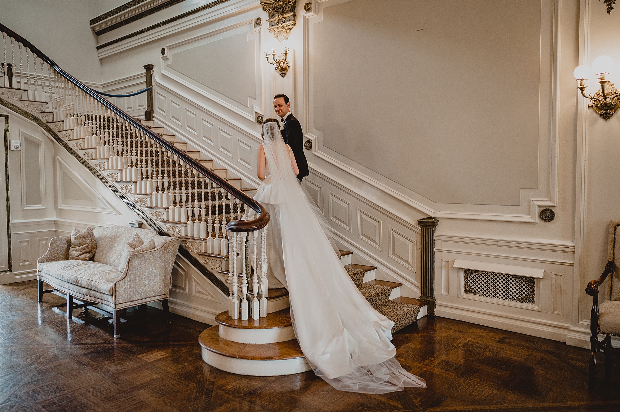 bride and groom walk upstairs inside Bourne Mansion