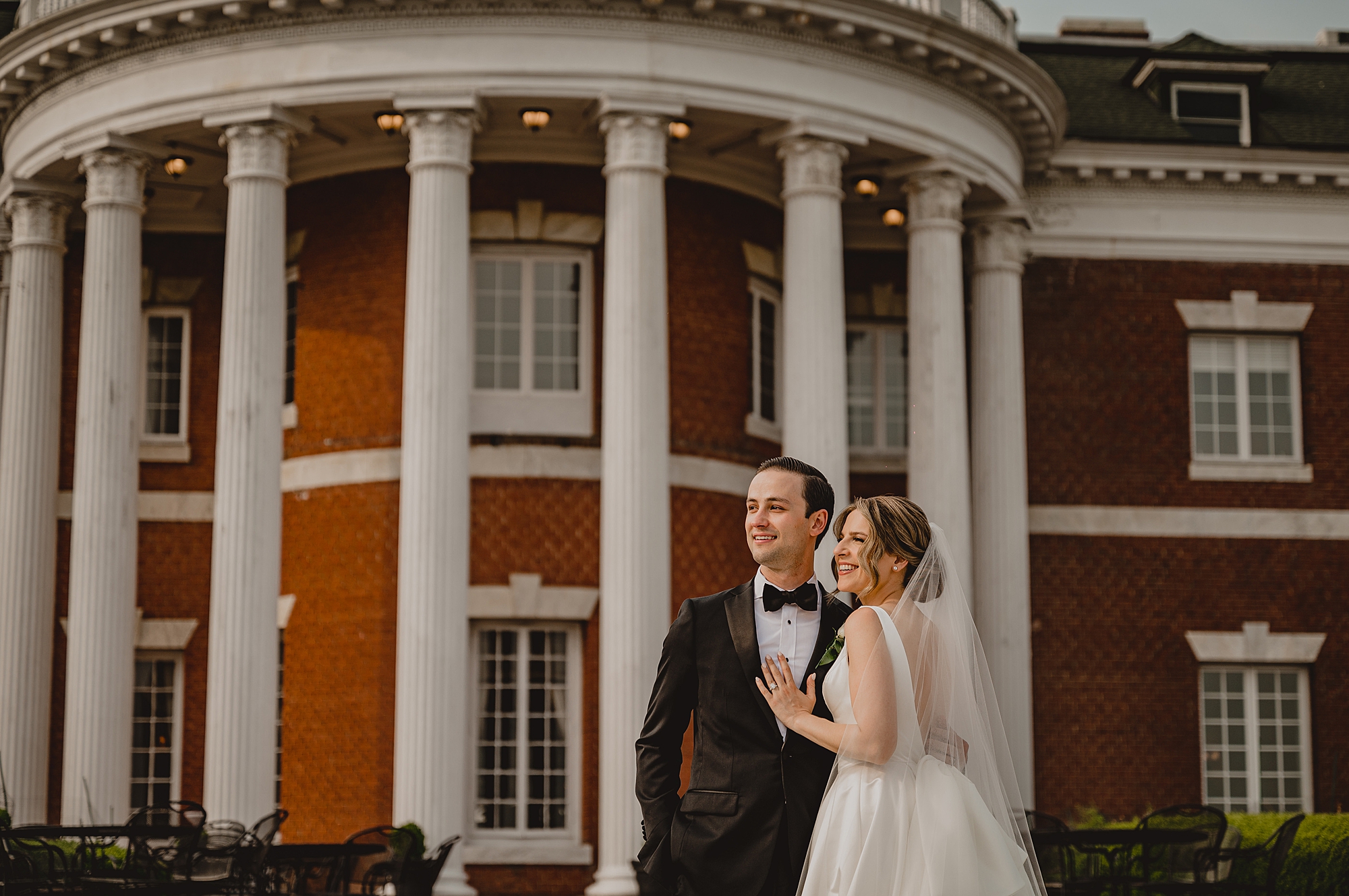 bride and groom hug outside the rotunda at Bourne Mansion