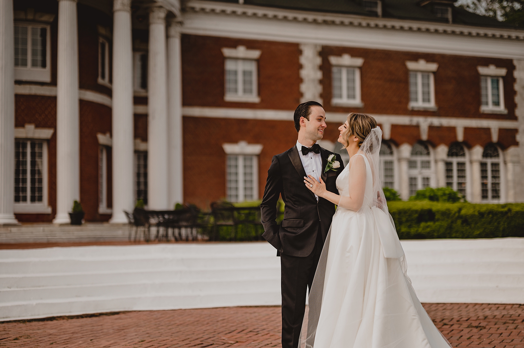 bride and groom hug outside the rotunda at Bourne Mansion