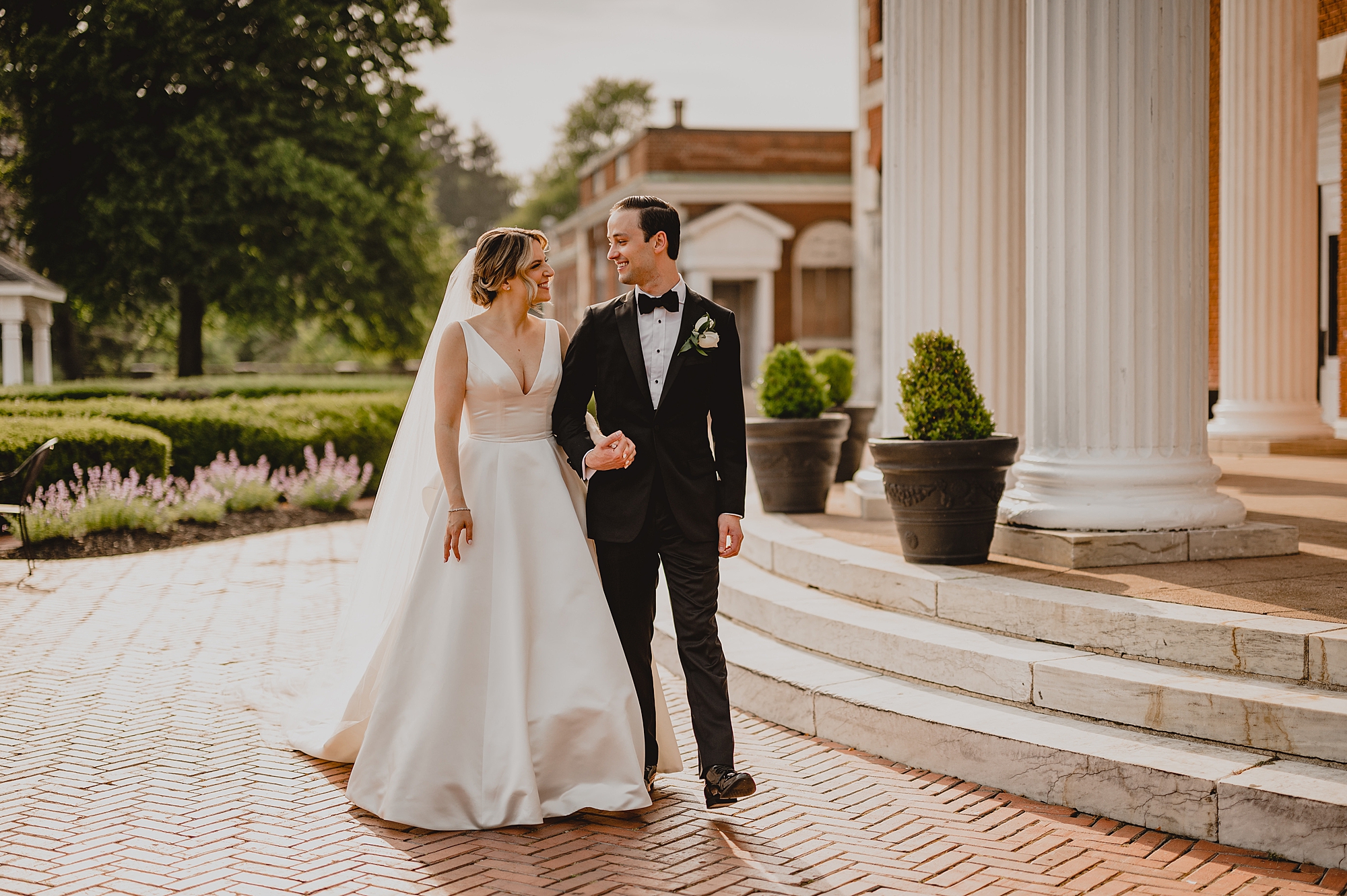bride and groom walk outside the rotunda at Bourne Mansion