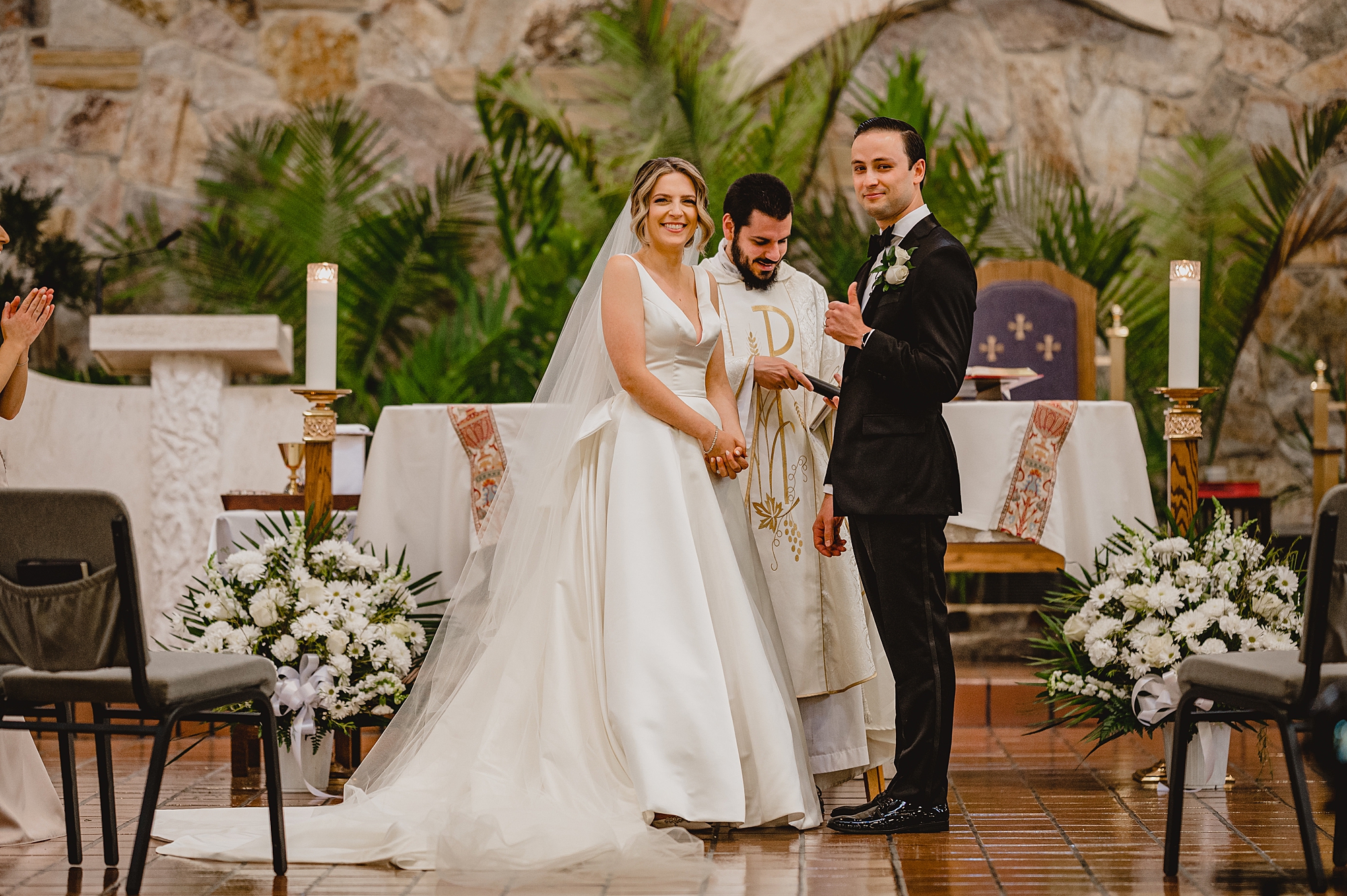 bride and groom hold hands during traditional church wedding on Long Island NY