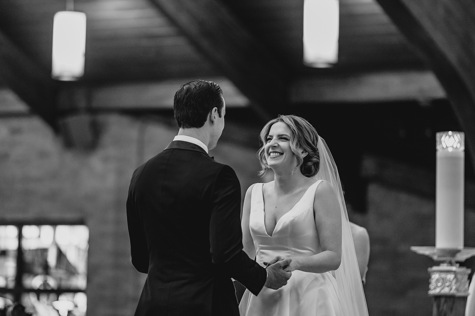 bride smiles up at groom during traditional church wedding on Long Island NY