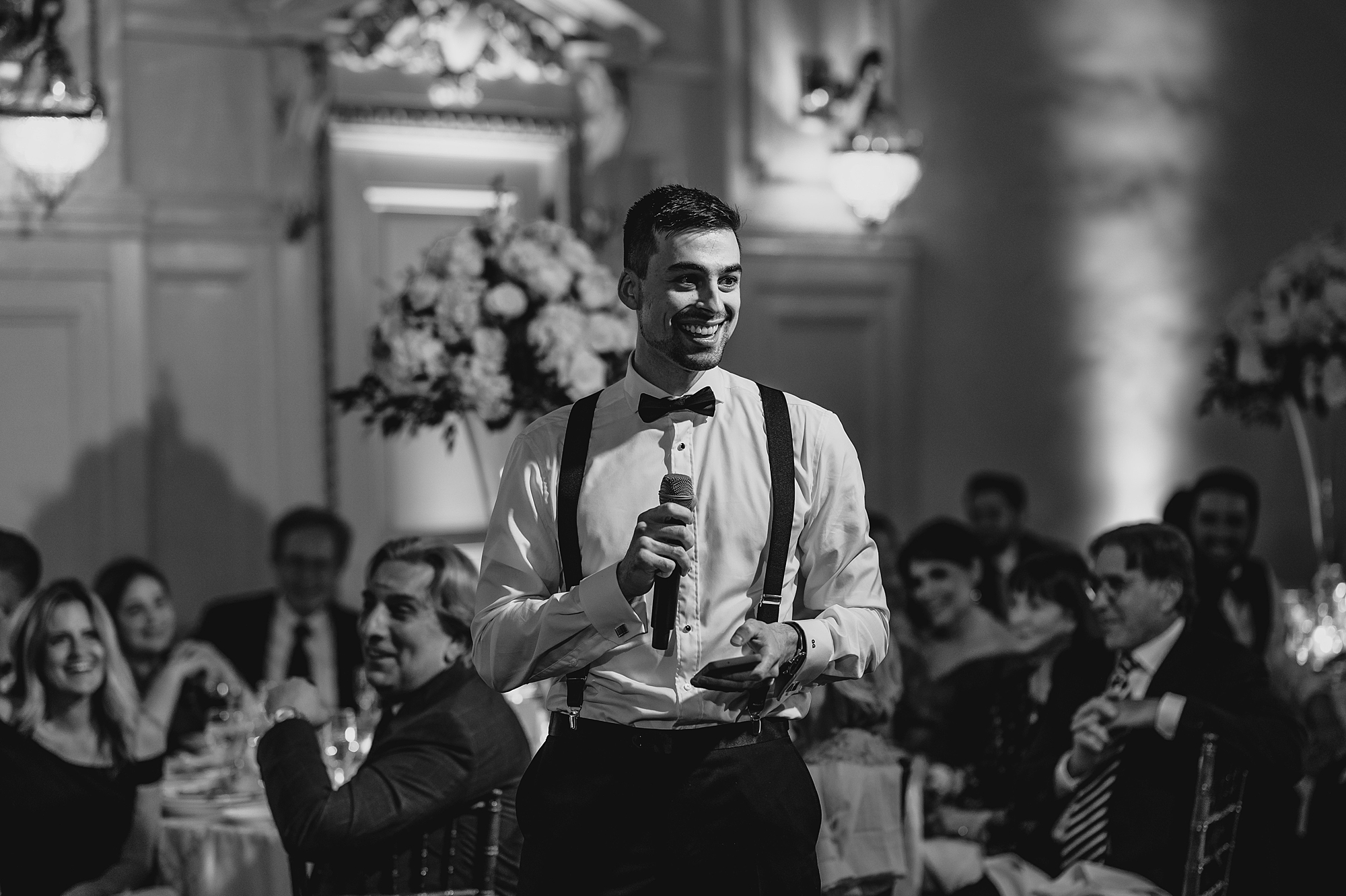 groomsman reads speech during Long Island wedding reception in the ballroom