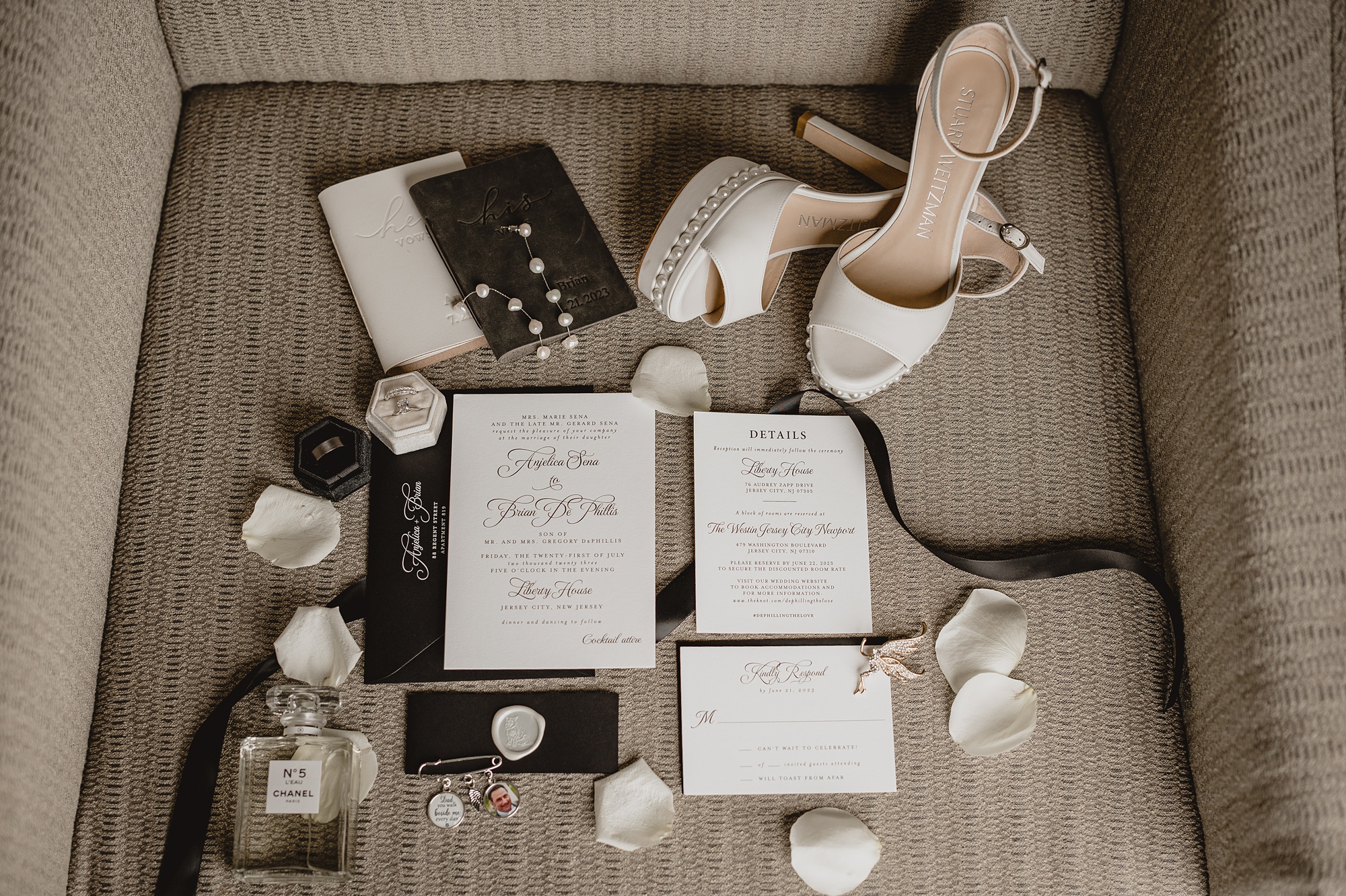 black and white stationery set with pearl jewelry and white rose petals