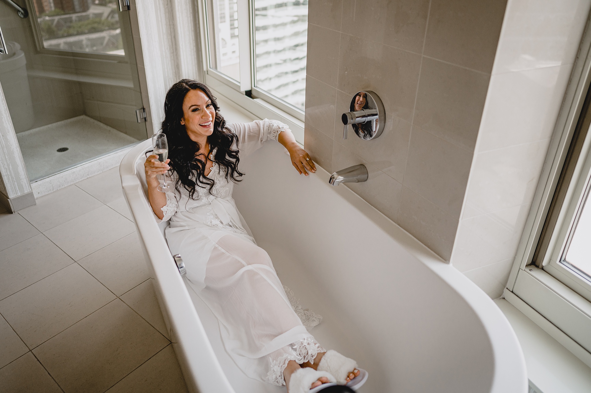 bride sits in bathtub in suite of New Jersey hotel room