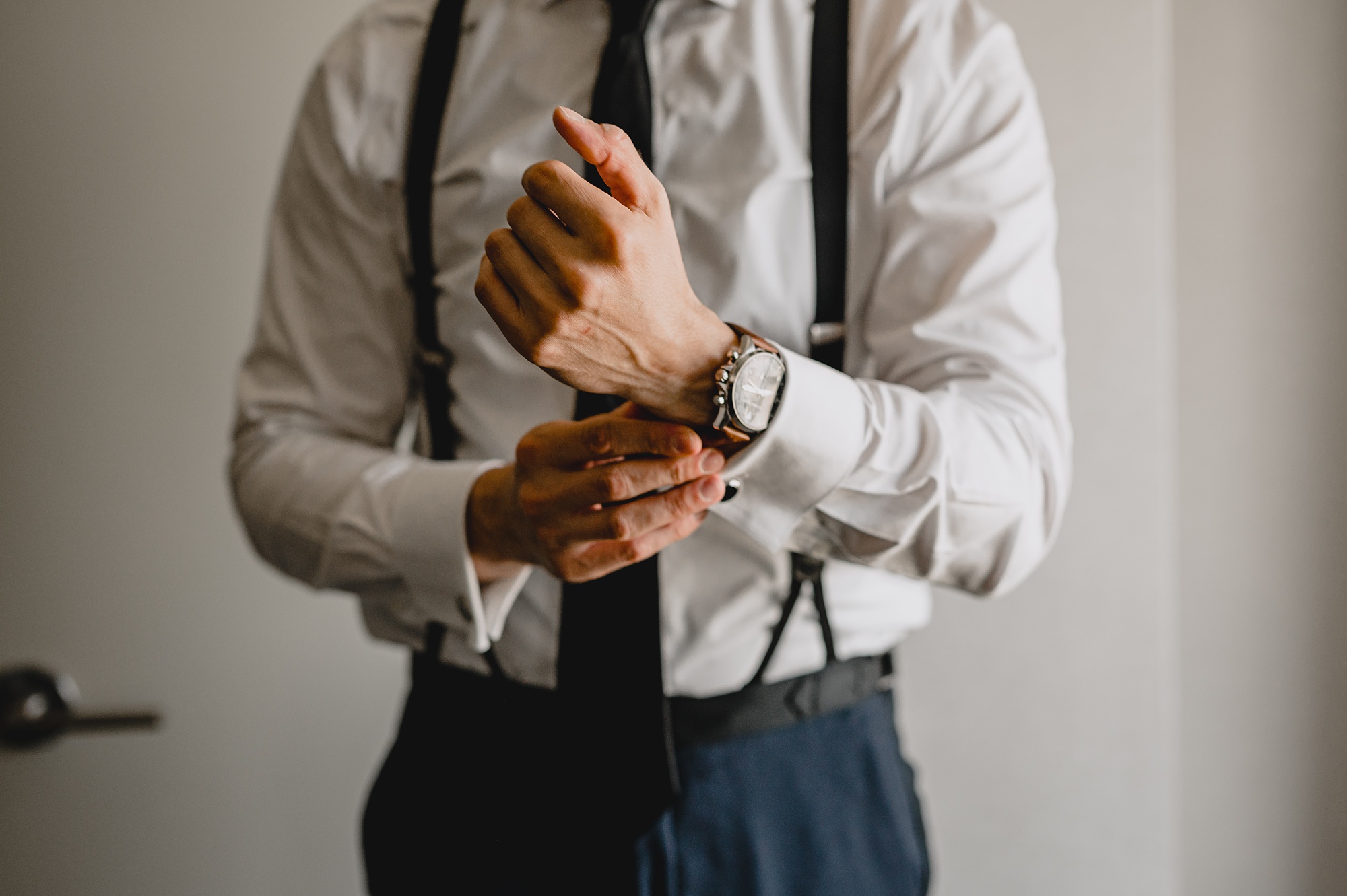 groom adjusts watch during prep of New Jersey hotel