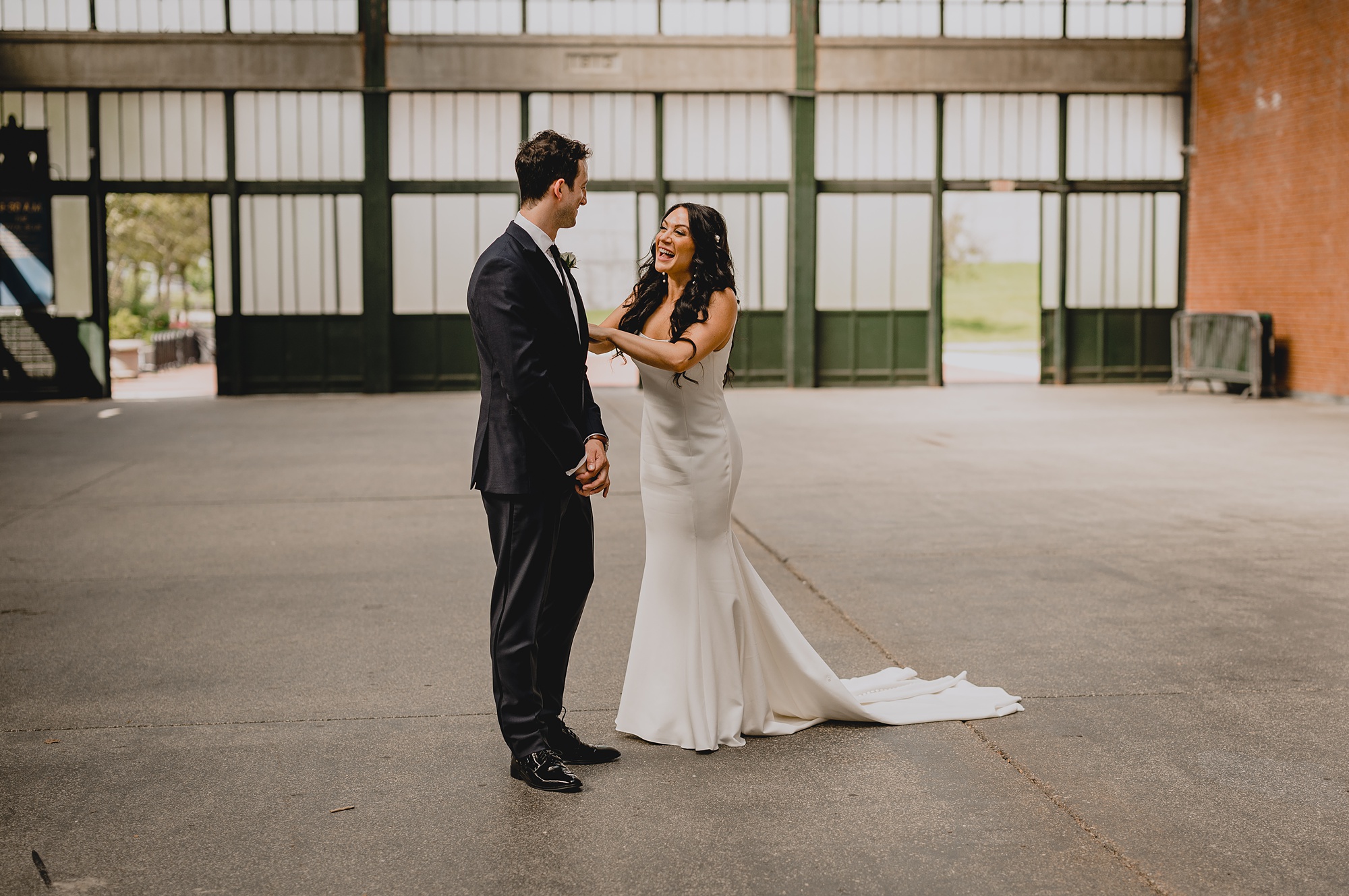 bride reaches to groom in front of the Liberty House