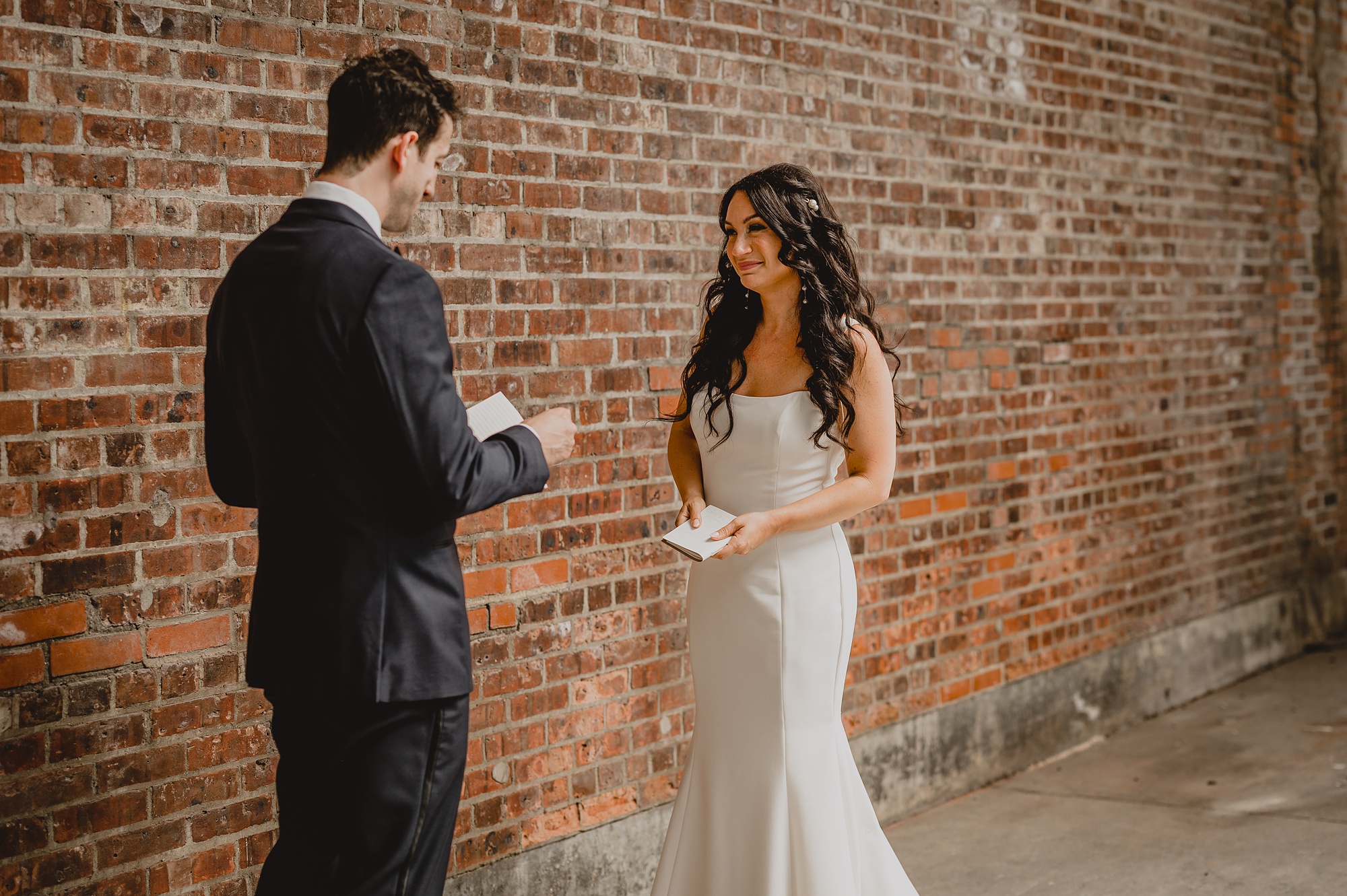 bride and groom read vows during first look outside the Liberty House