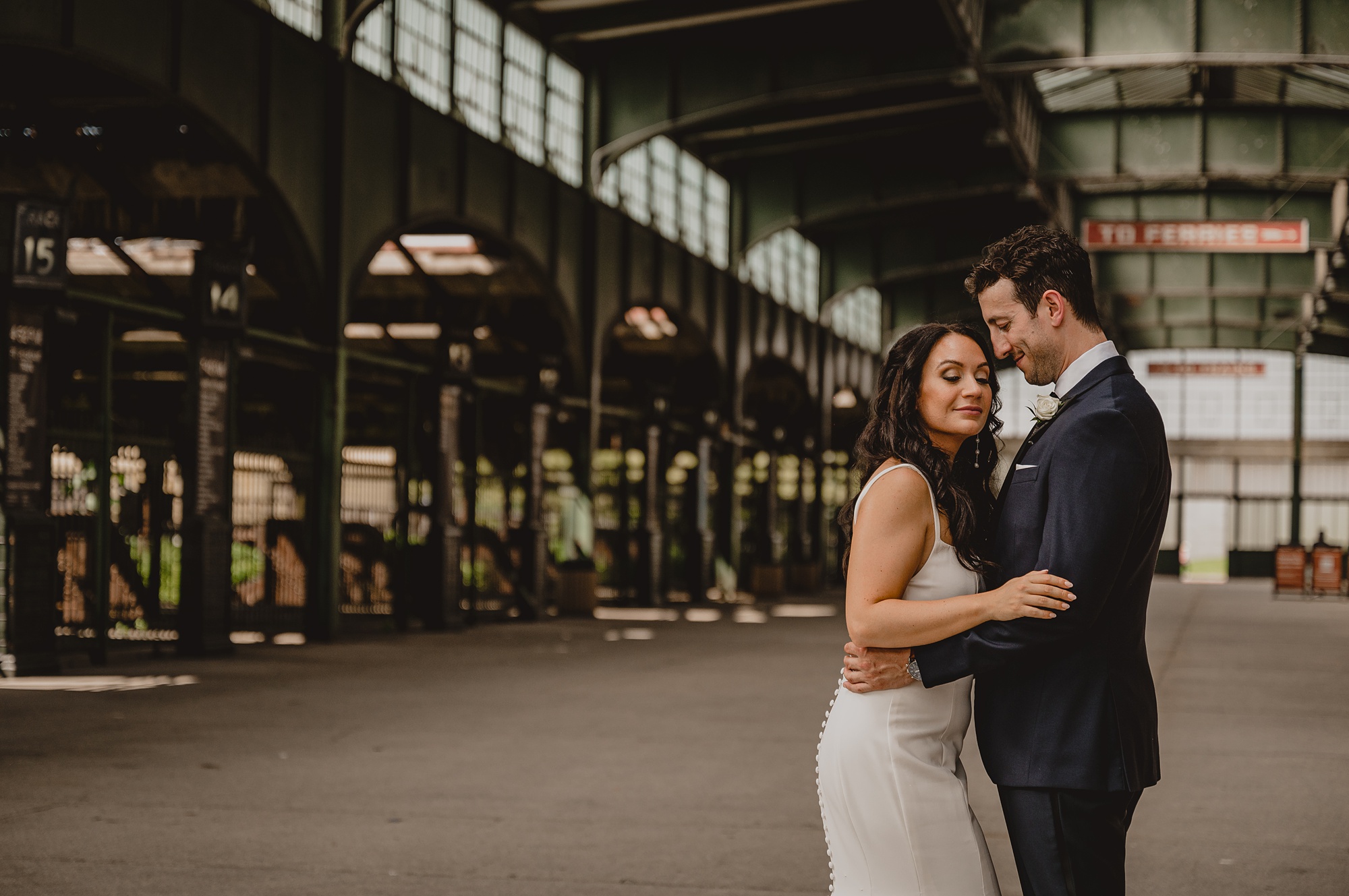 groom hugs bride kissing her head in terminal outside the Liberty House
