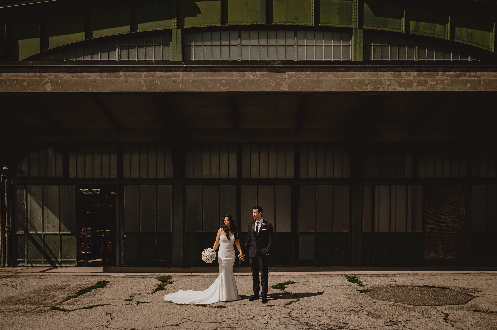 bride and groom hold hands outside the Liberty House