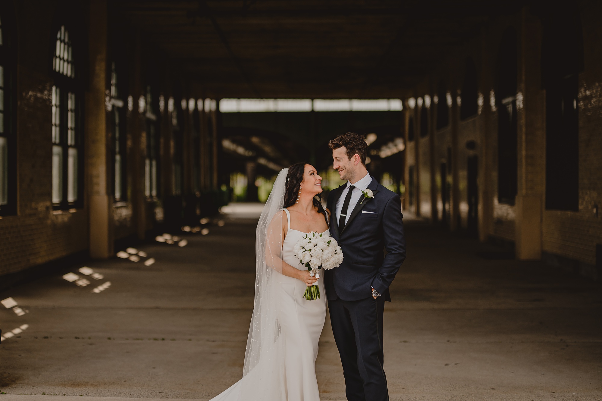 bride and groom hug between terminal stations at the Liberty House
