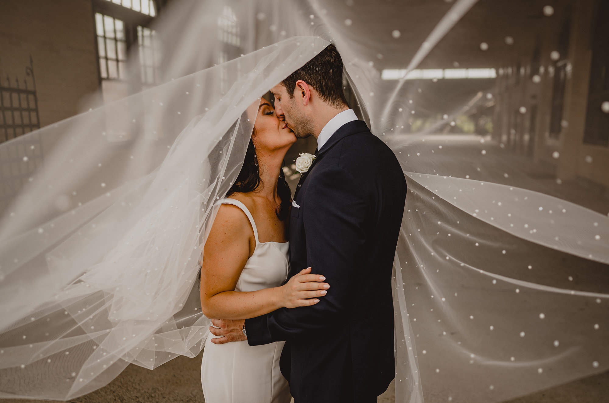 newlyweds kiss under veil at the Liberty House