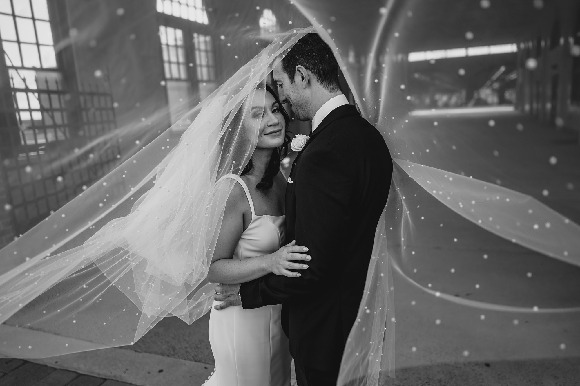 bride and groom hug under sparkly veil at the Liberty House