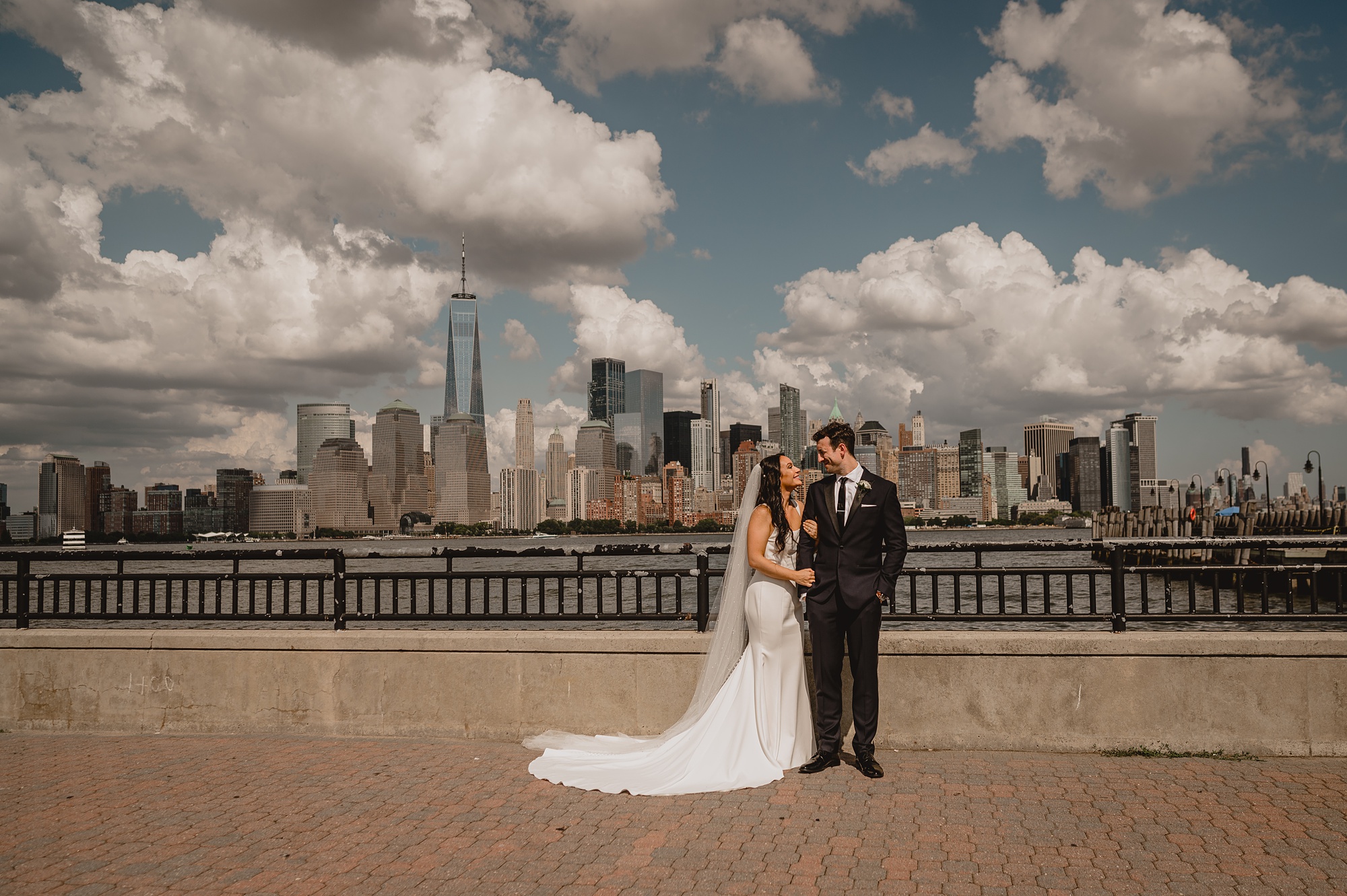 newlyweds hug in front of the Hudson River at the Liberty House