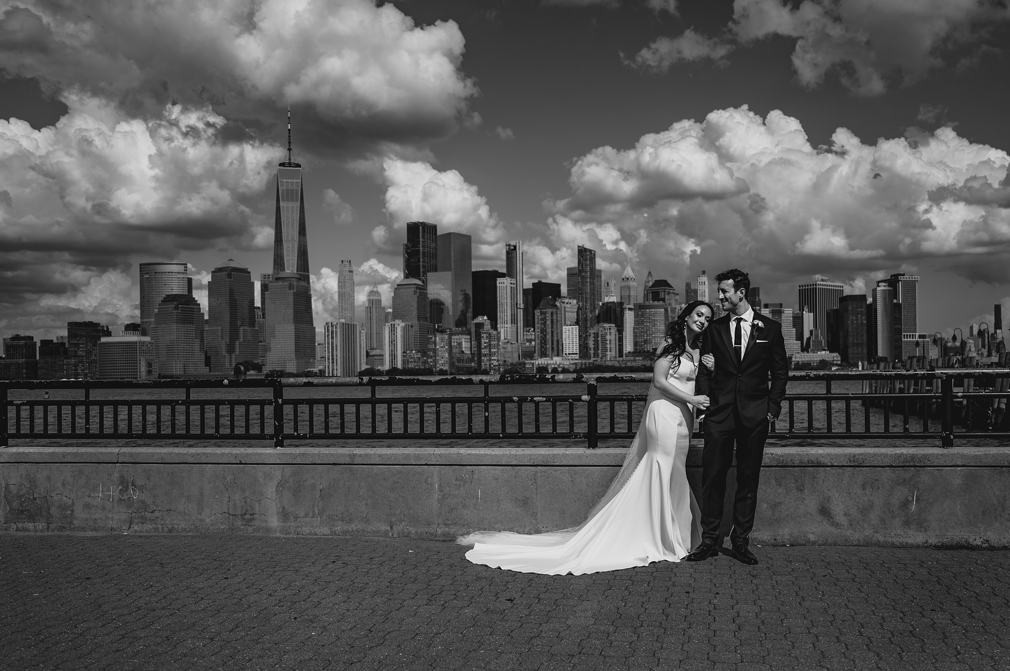 newlyweds hug in front of the Hudson River at the Liberty House