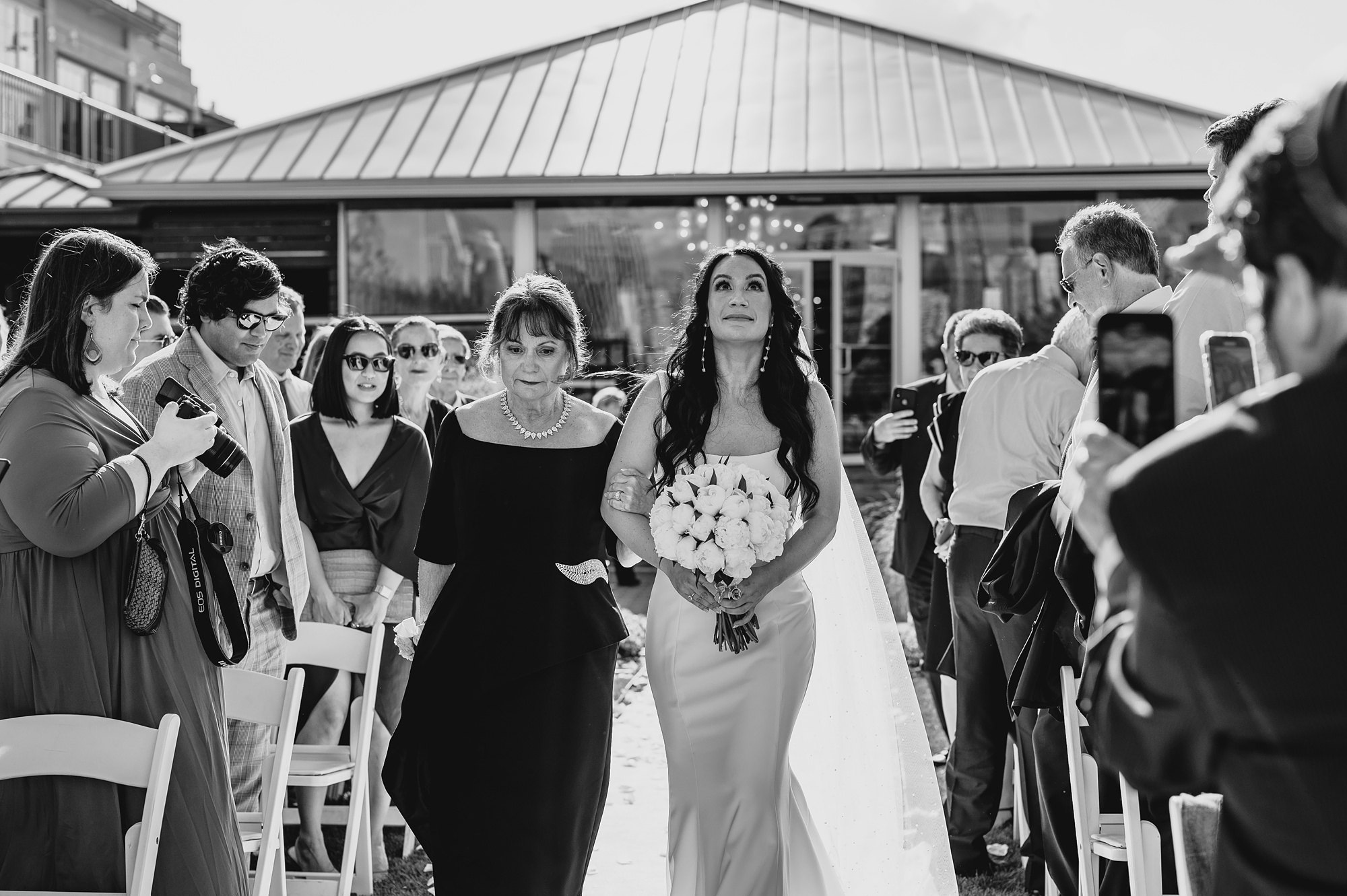 bride smiles walking down aisle with mother at the Liberty House
