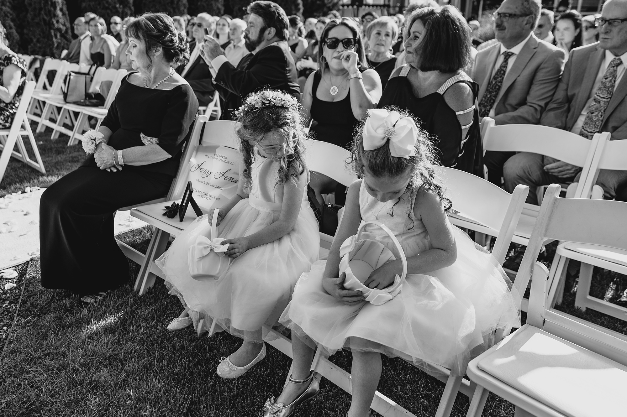 flower girls sit on folding chairs during wedding ceremony at the Liberty House