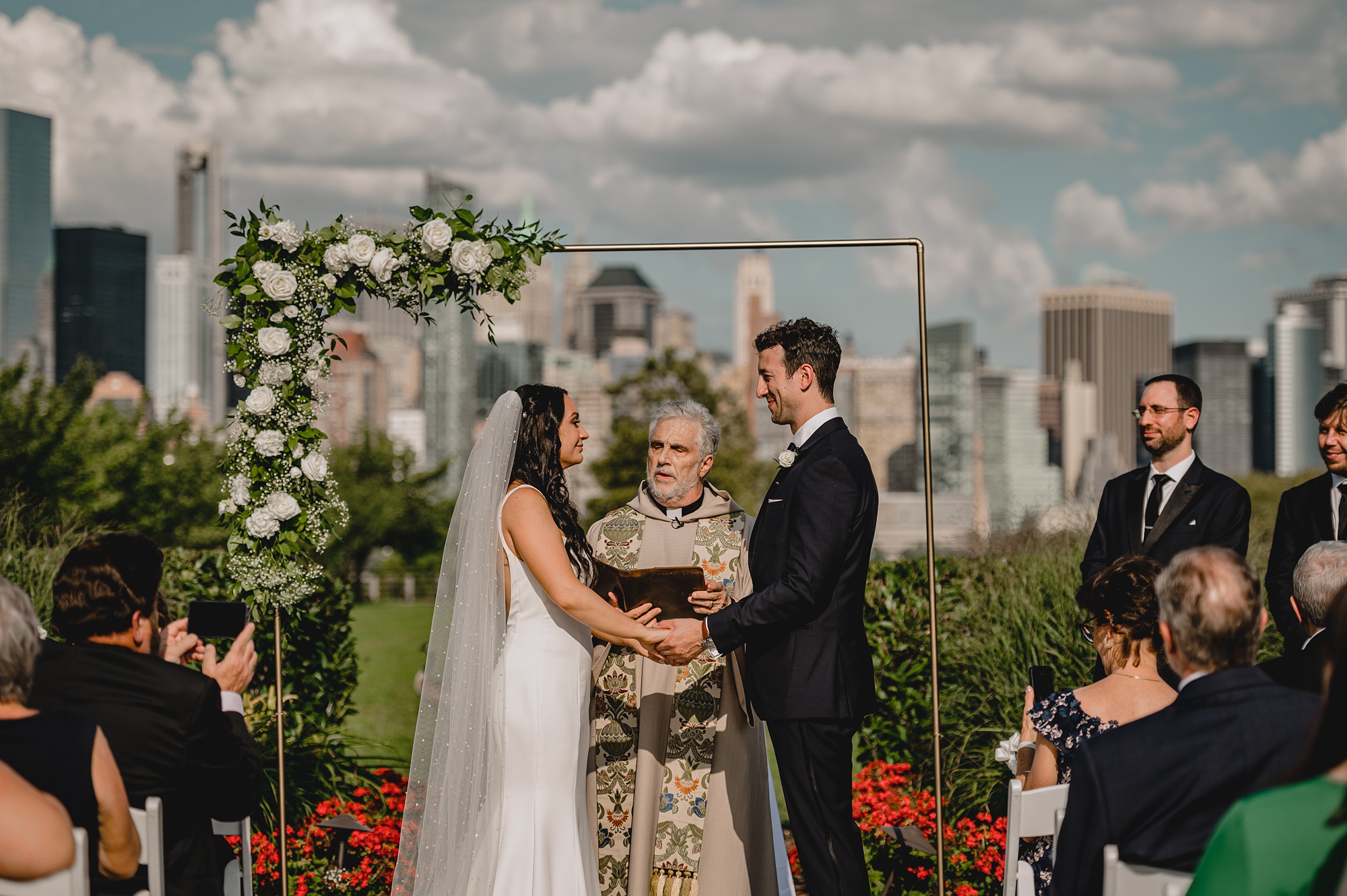 bride and groom hold hands during wedding ceremony at the Liberty House