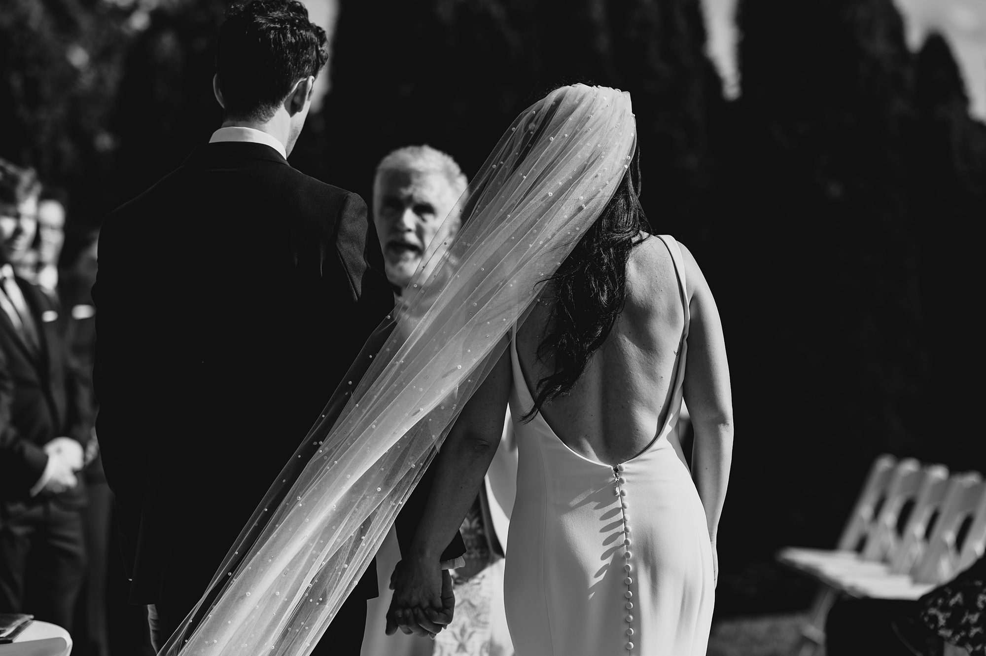 priest looks at bride and groom during wedding ceremony at the Liberty House