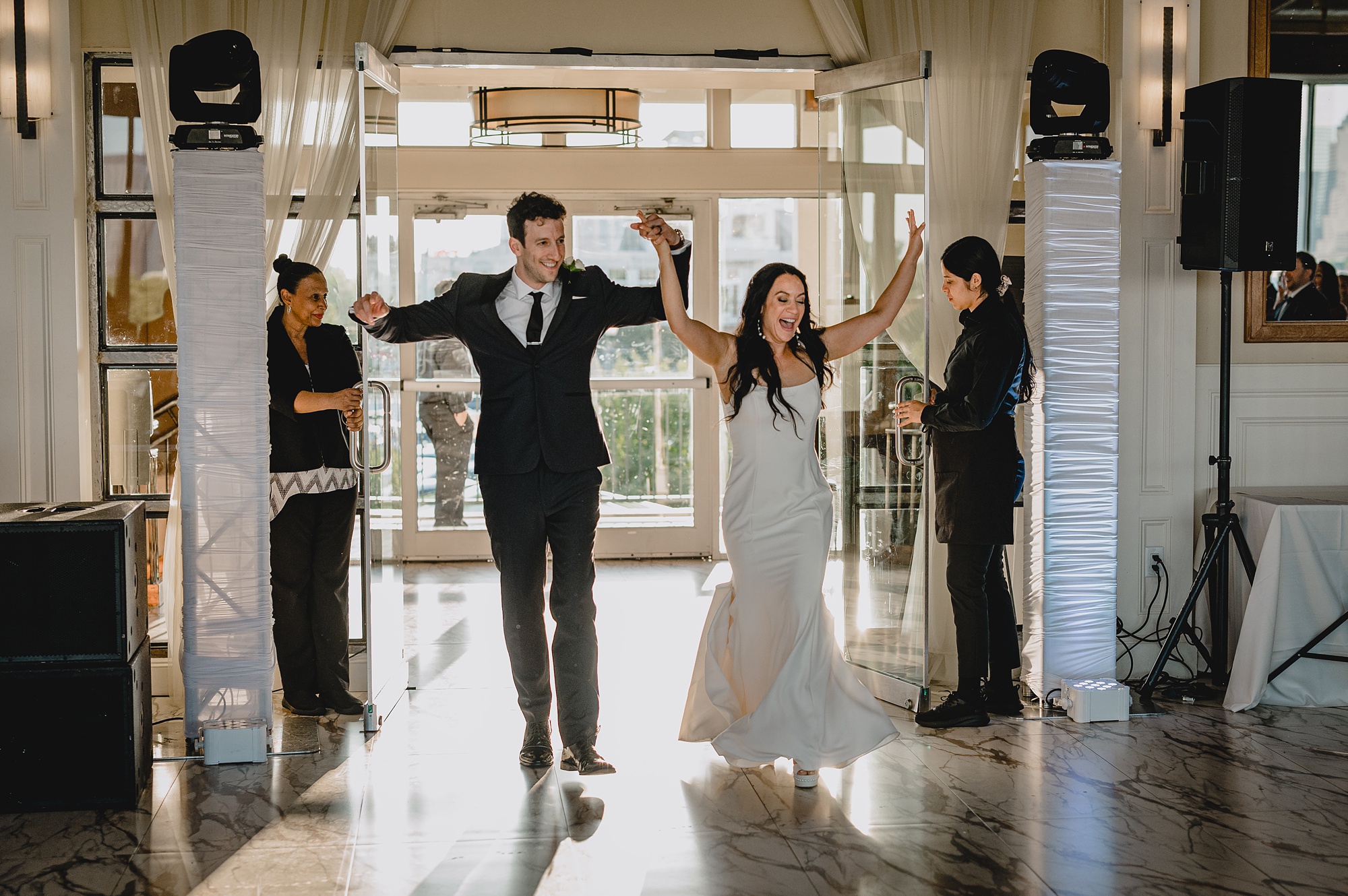 newlyweds cheer walking into reception at the Liberty House