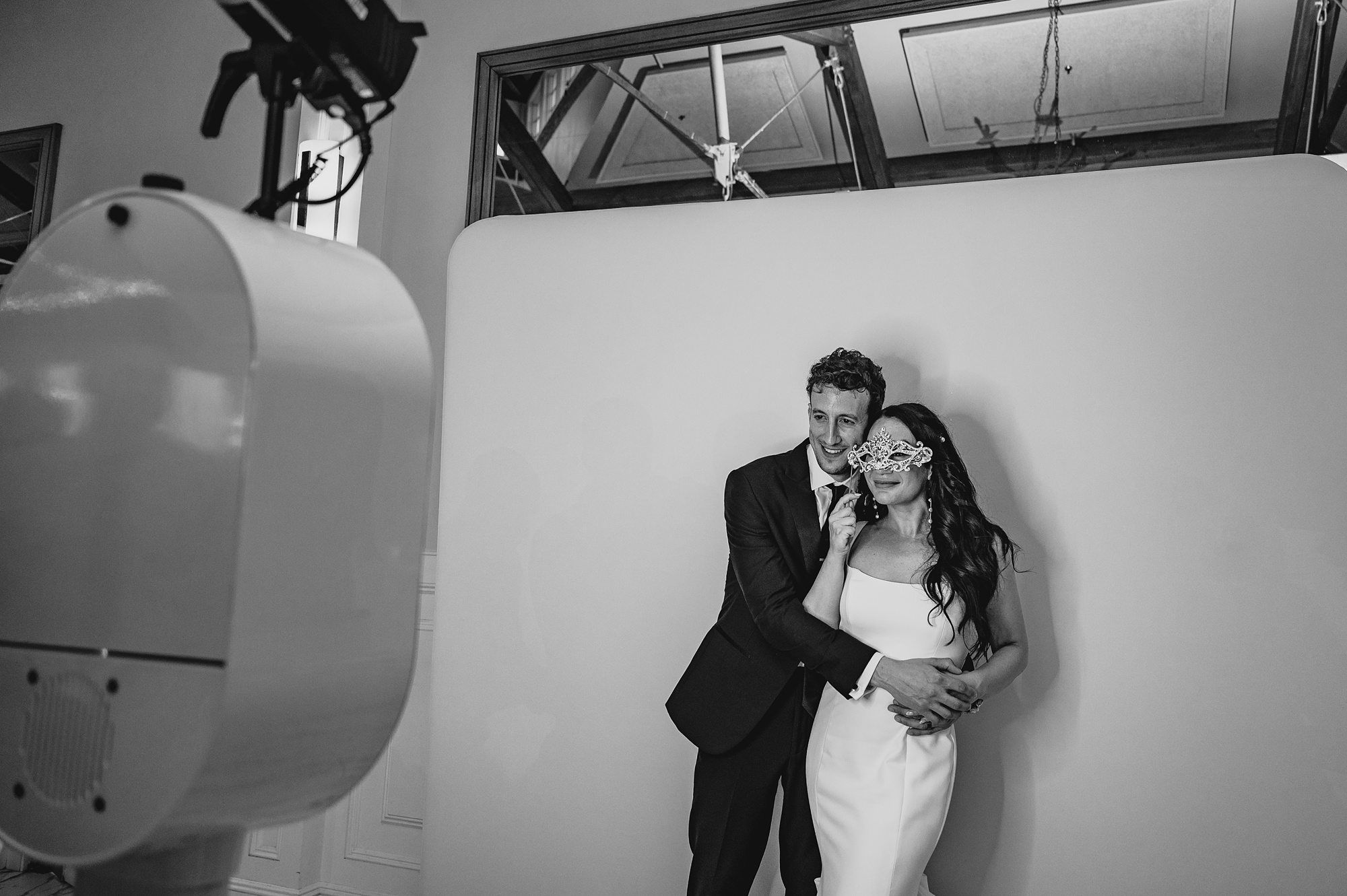 bride and groom hug in front of photo booth